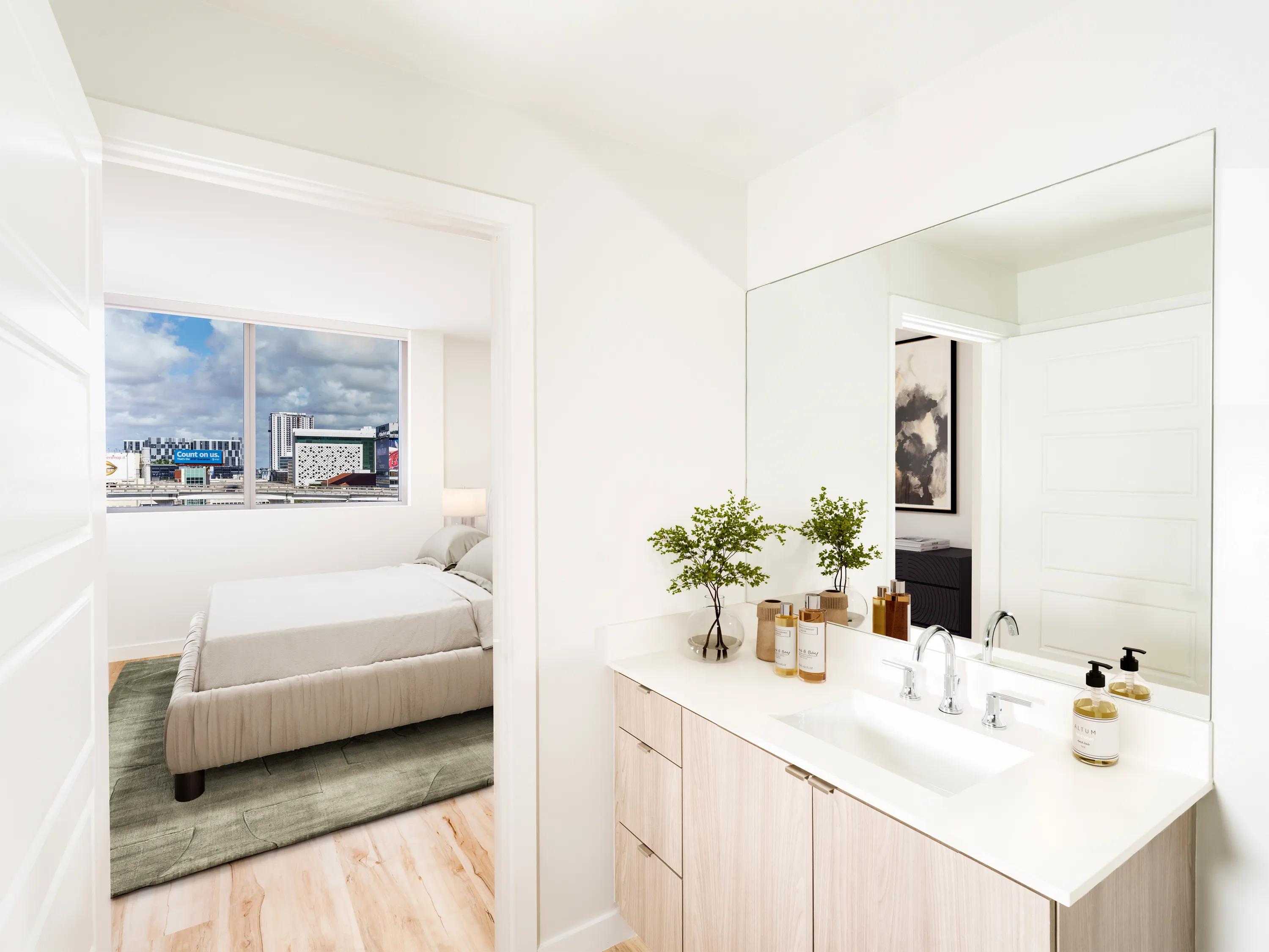 bathroom with large mirror looking into bedroom modera riverside apartment homes for rent in miami fl