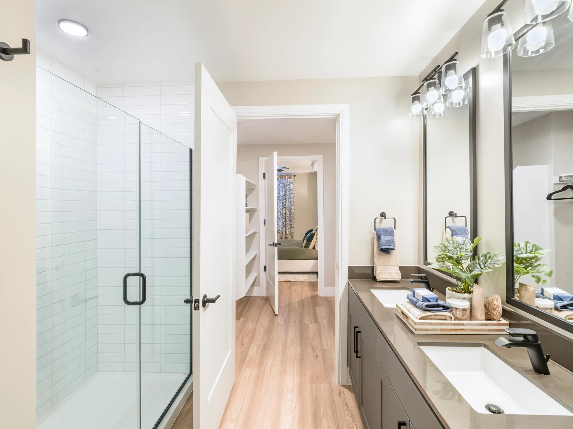 tiled shower and double vanity bathroom with pass through closet at modera scottsdale apartment homes for rent in scottsdale az