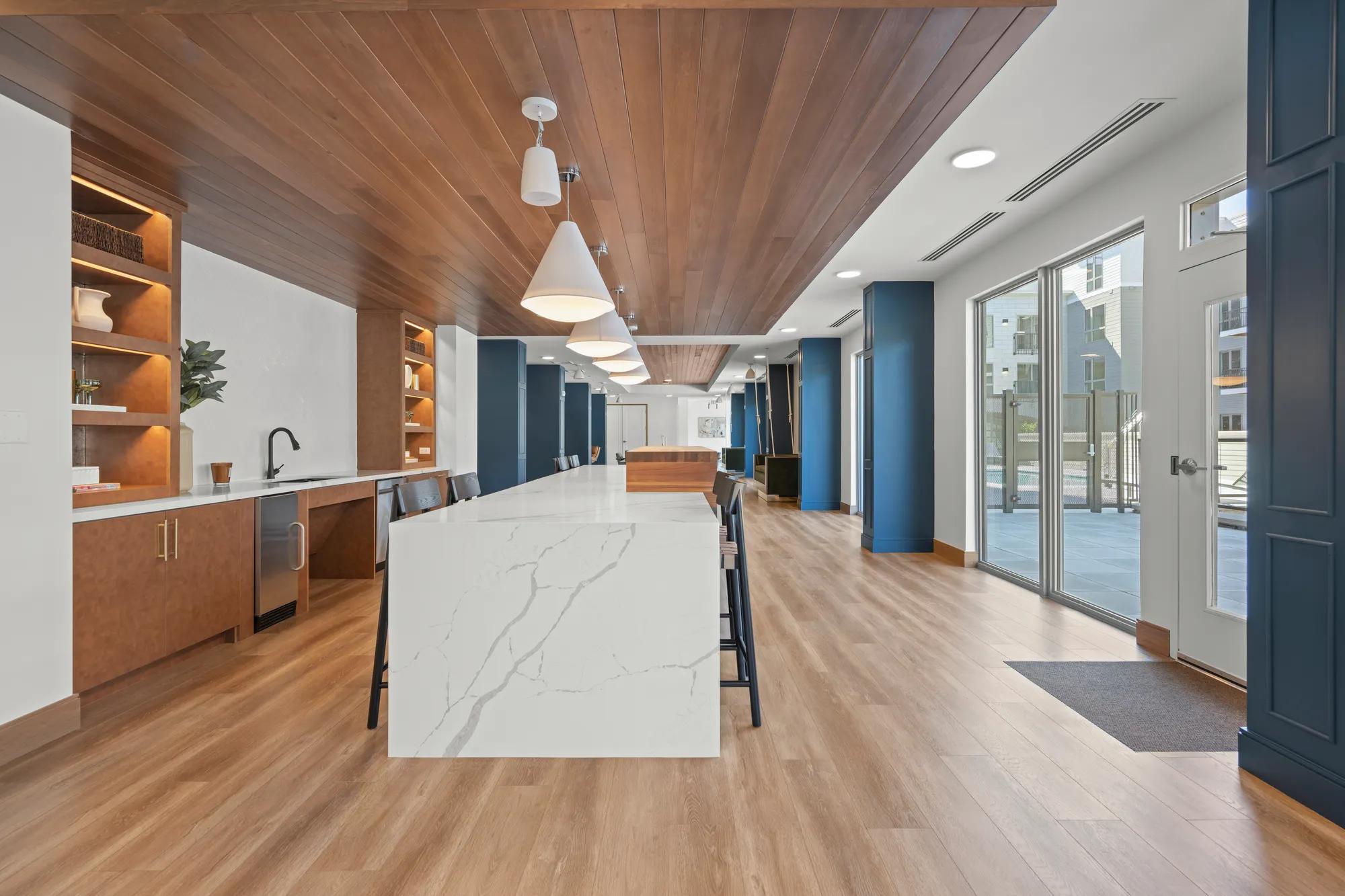 demonstration kitchen with large white quartz island at modera newton apartment homes for rent in ma