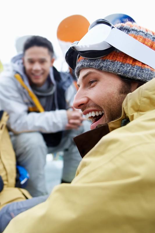 man smiling with friends while wearing ski gear modera art park apartments