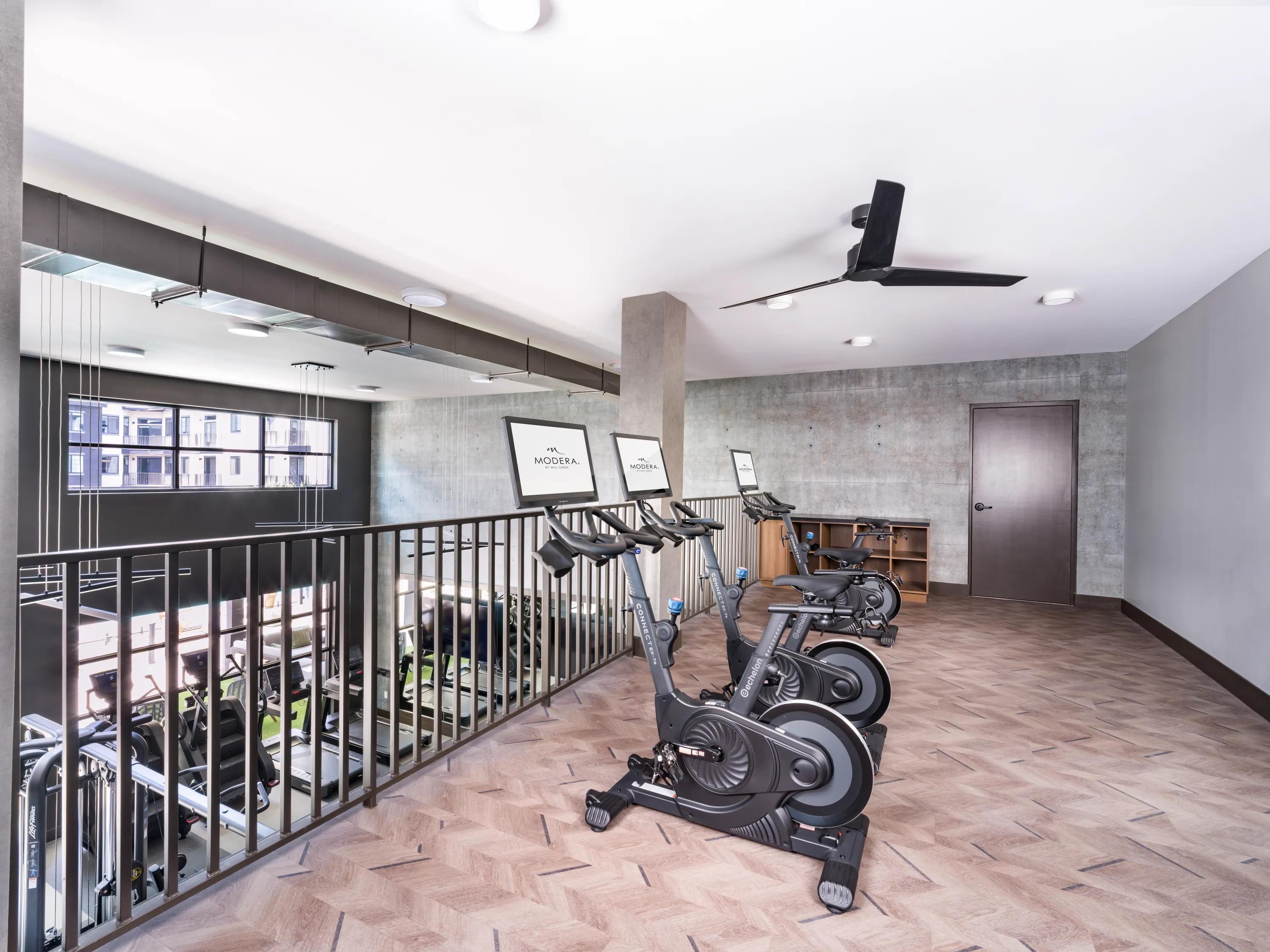 Two-story fitness studio with stationary bikes, open workout space, modern finishes, and premium exercise equipment at apartments in Chandler, AZ.