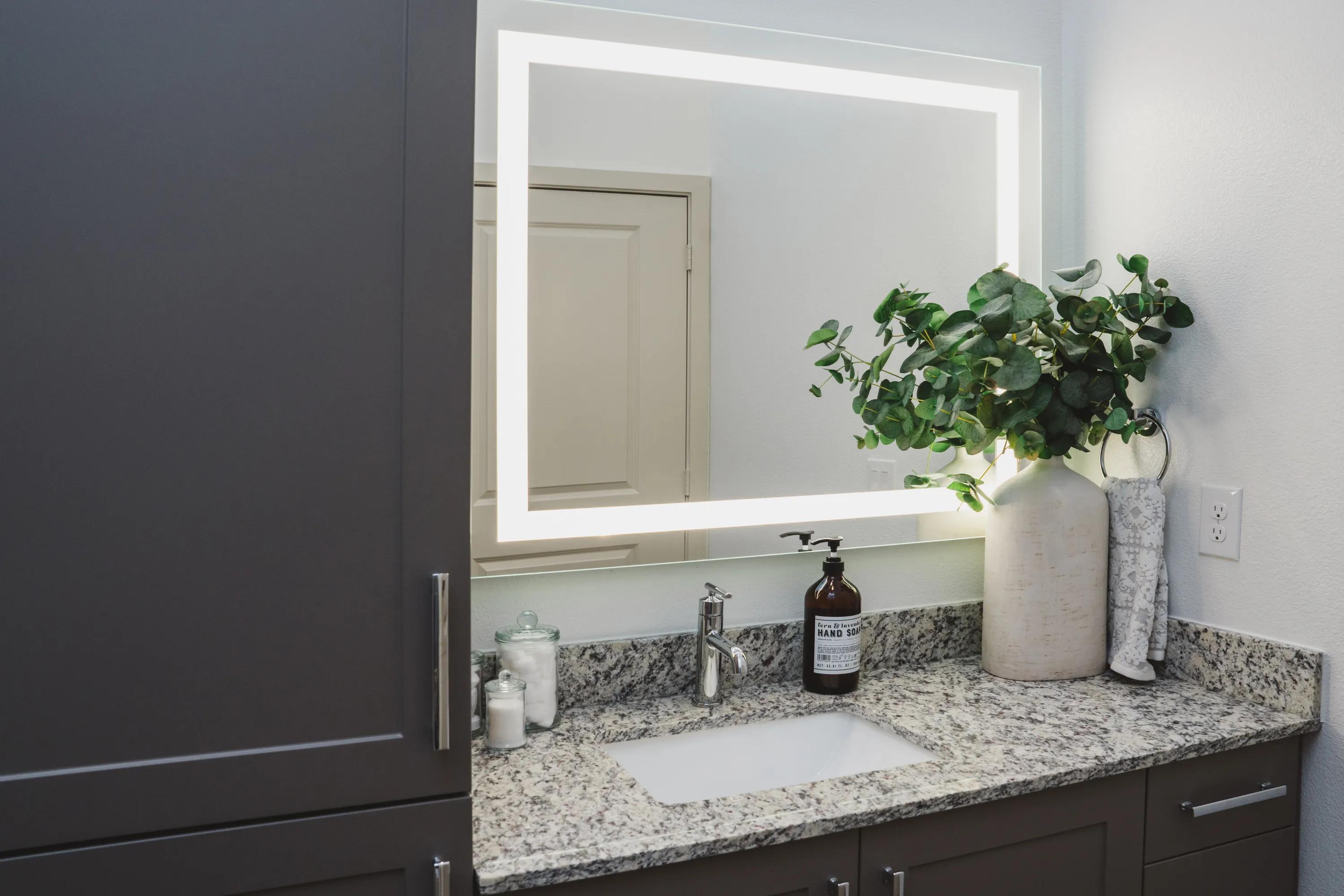 Designer bathrooms with double vanities*, granite countertops, and backlit mirrors modera frisco square apartments
