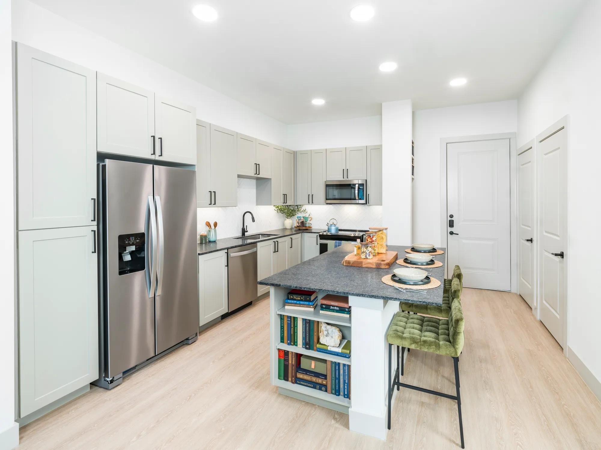 kitchen with stainless steel appliances and large kitchen island leading into living area modera mckinney ridge tx