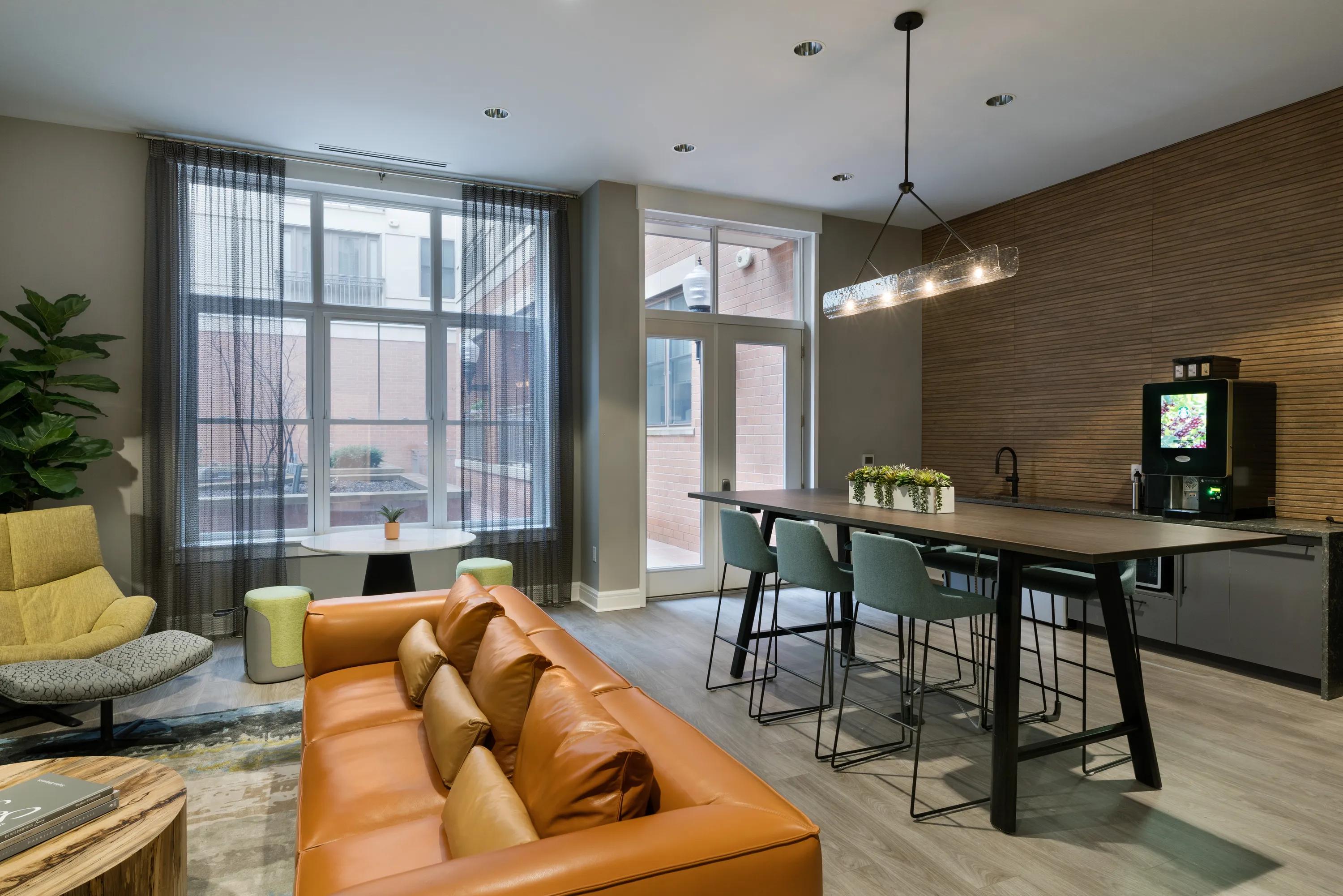 coffee bar and large table in clubhouse leading to courtyard metropolitan at 40 park apartment homes for rent in morristown nj