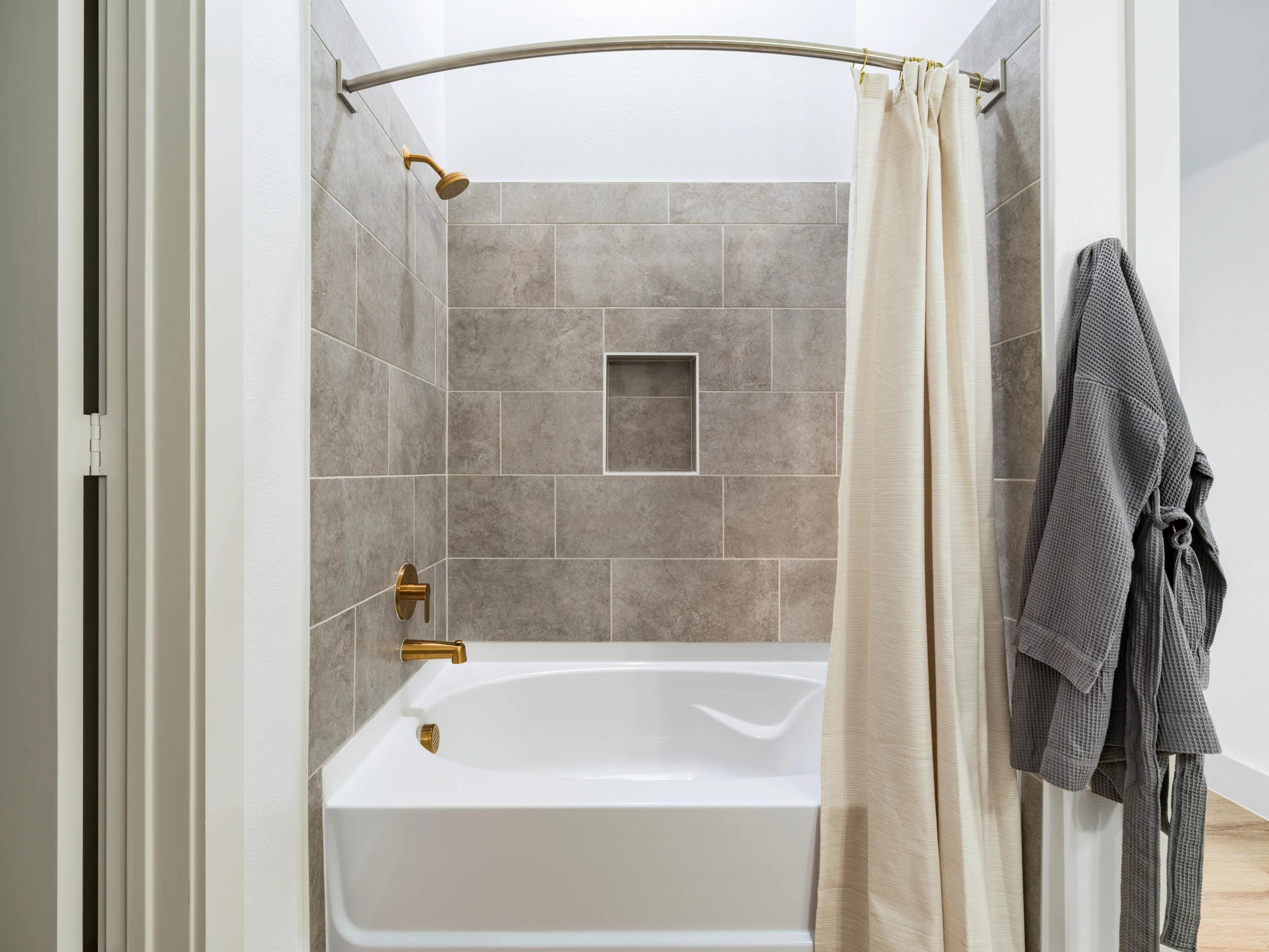 primary bath with a tiled tub and shower modera walsh heights apartments aledo tx