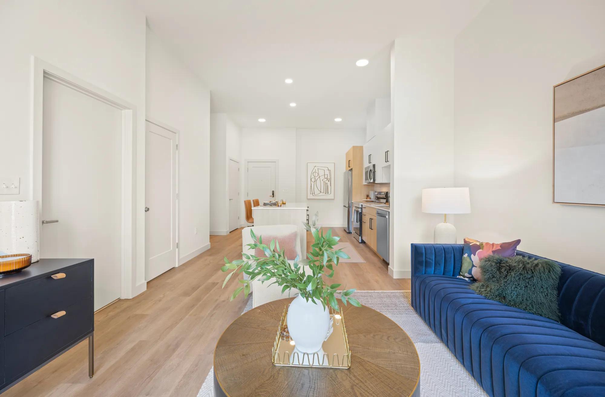 seating area looking towards kitchen with large island at modera newton apartment homes for rent in ma