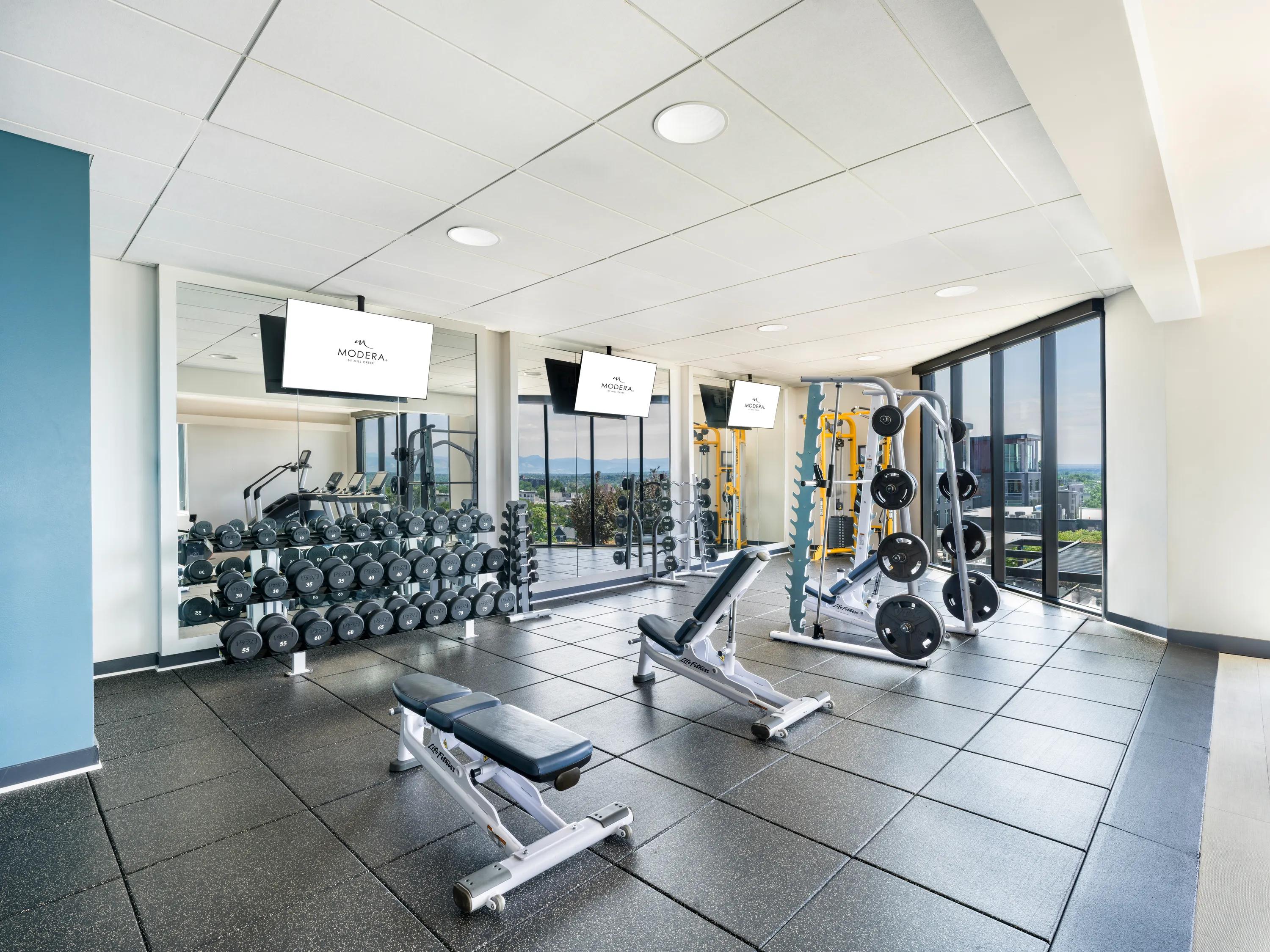 Fitness equipment closeup with weight stations and rowers and bike in view