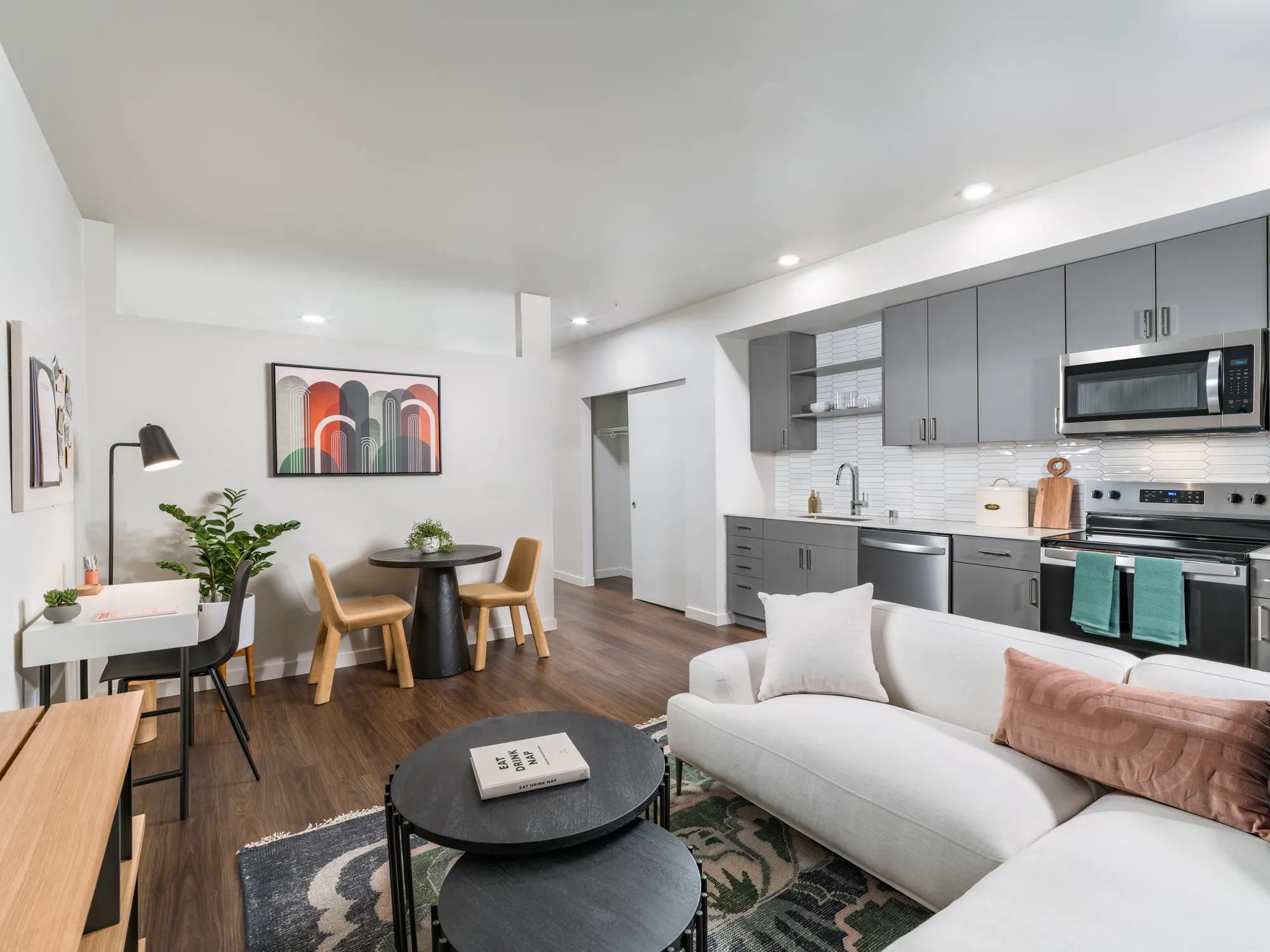 living room looking onto kitchen with large windows and couch modera northgate apartment homes for rent in seattle wa