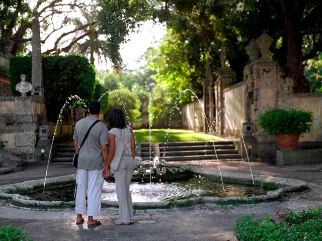 couple holding hands in front of fountain in park modera riverside apartment homes for rent in miami fl