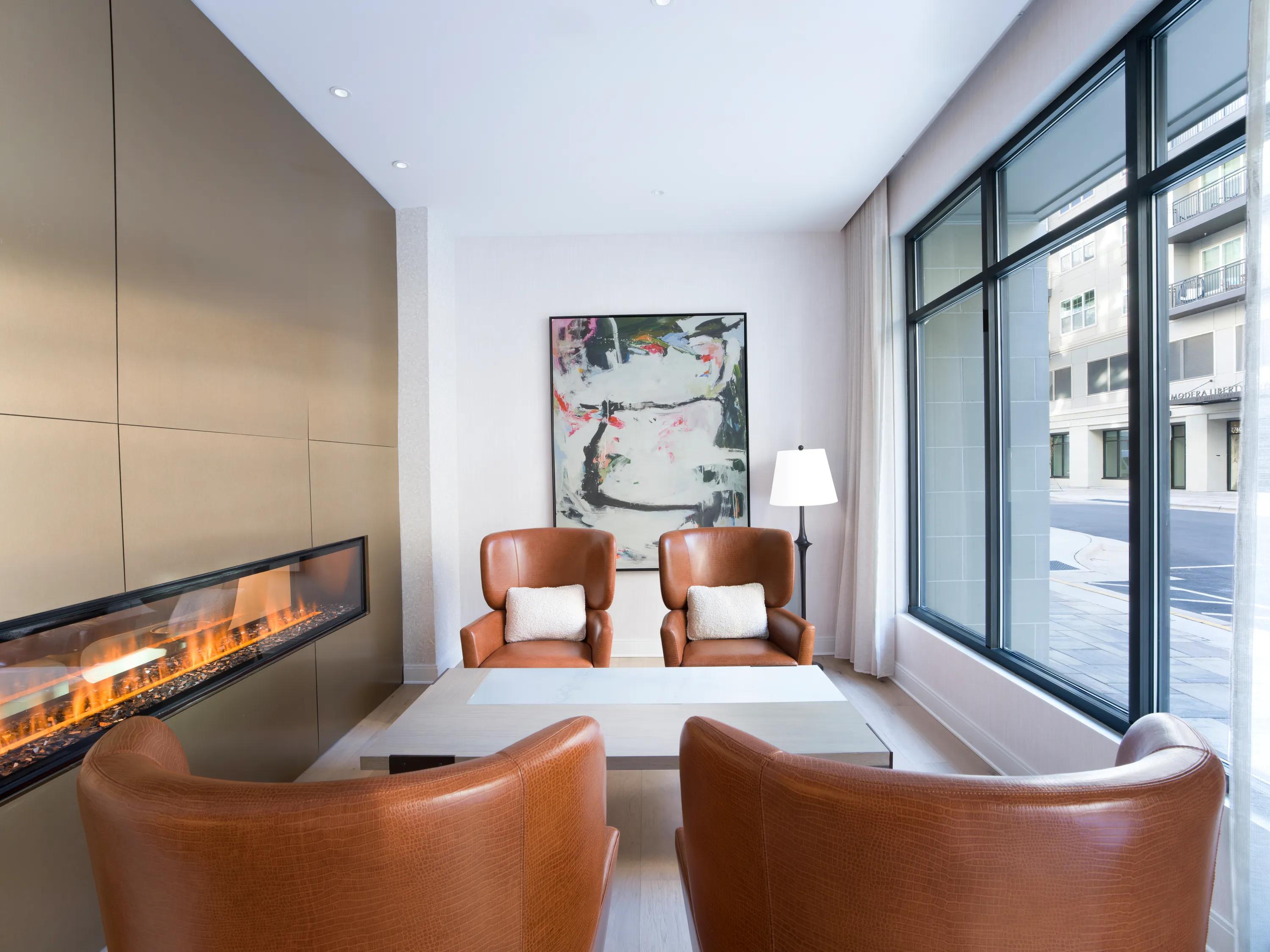 cozy lounge with fireplace and comfy chairs modera liberty row charlotte nc apartments