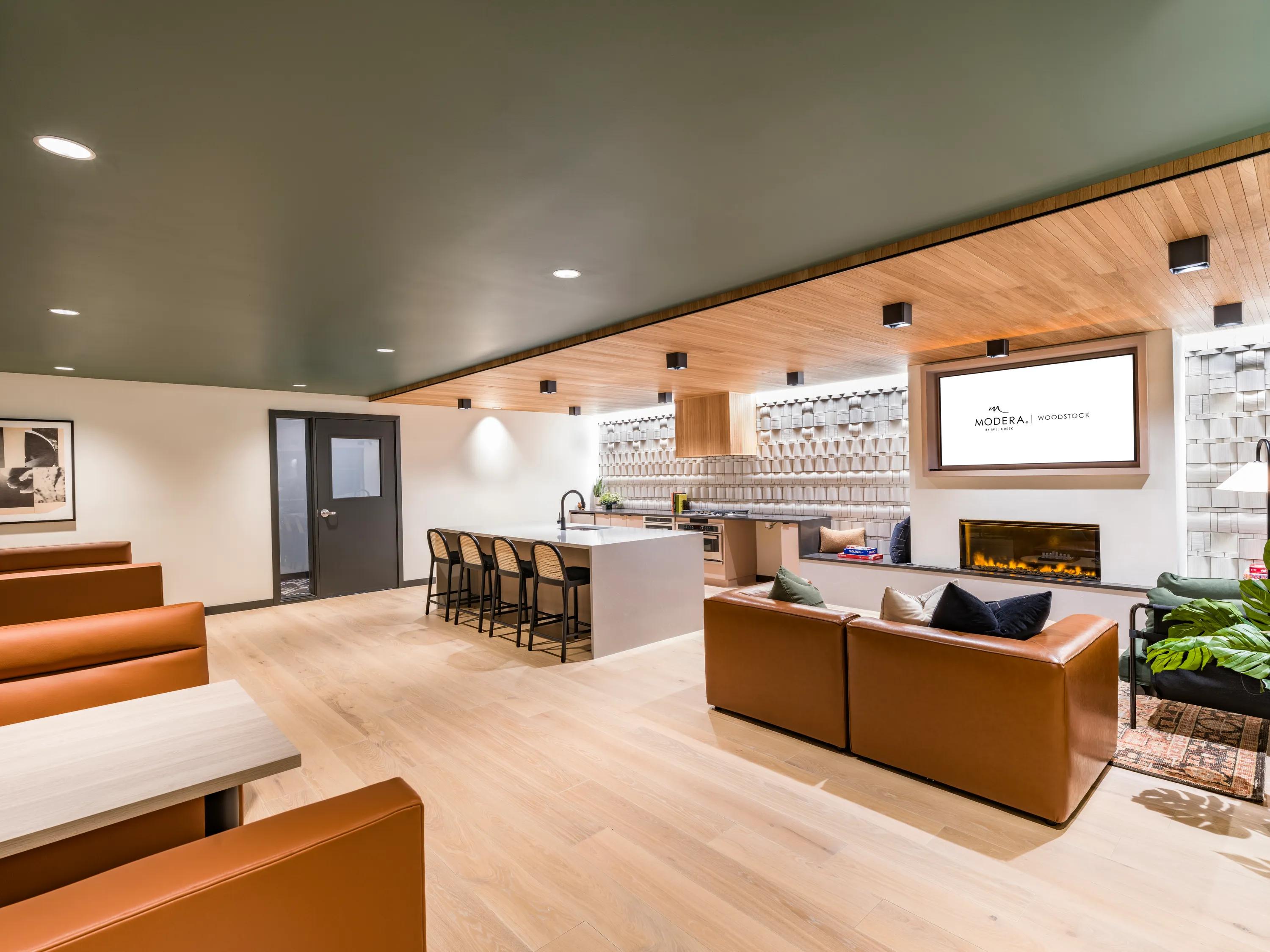 Modera Woodstock's stylish clubroom with fireplace and TV lounge