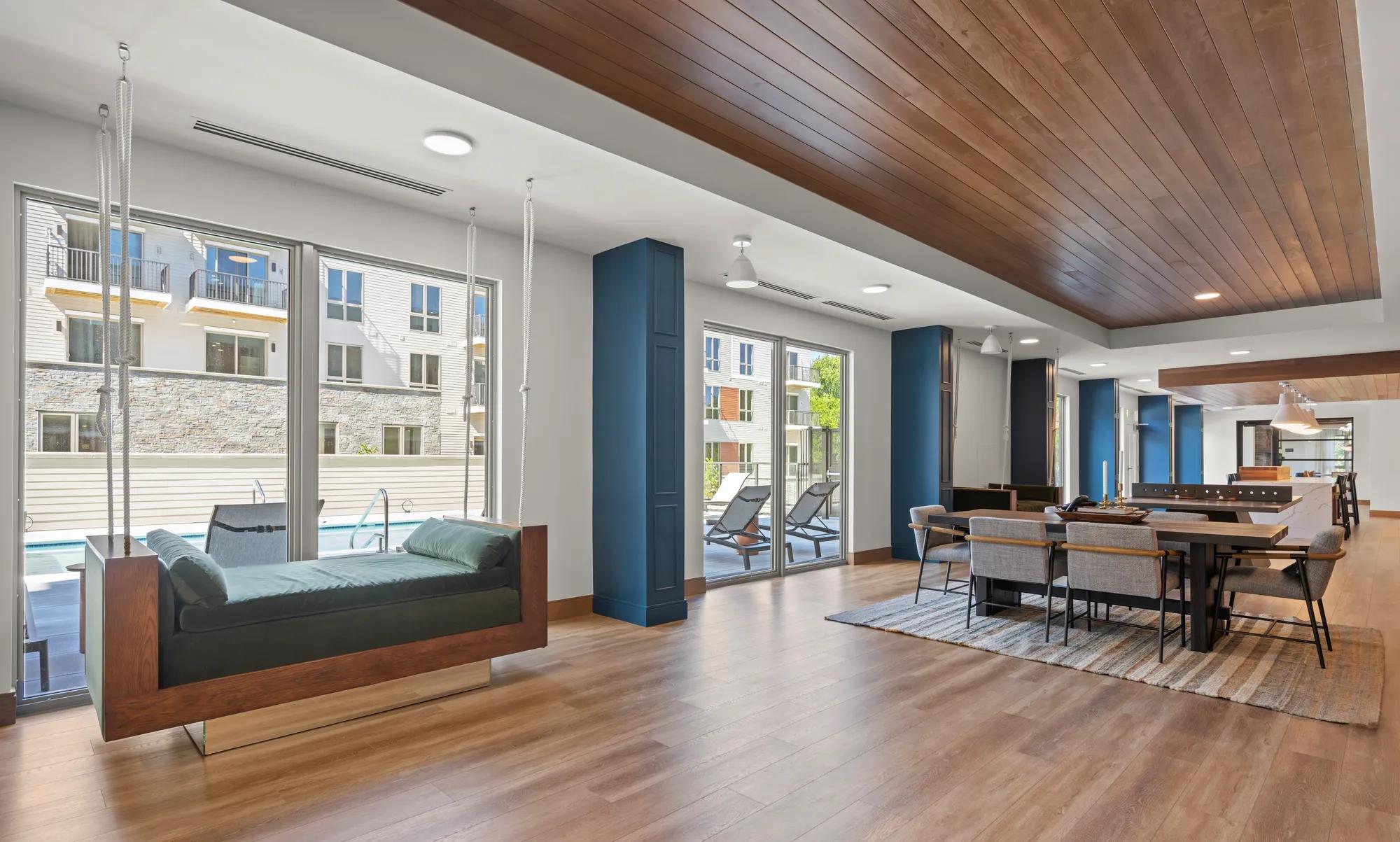 clubhouse gaming room looking onto outdoor courtyard at modera newton apartment homes for rent in ma
