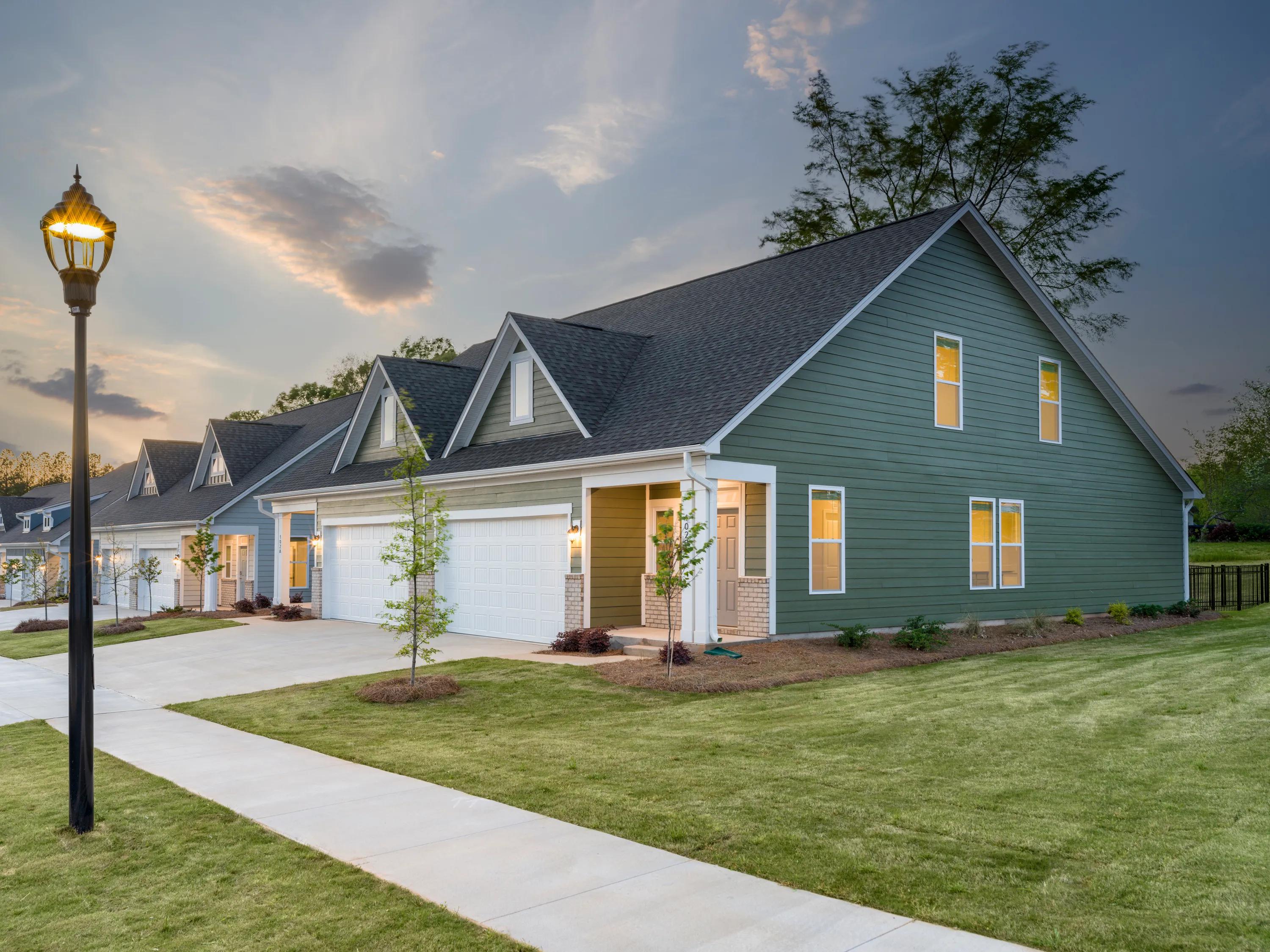 large sideyard at dusk with landscaping and garage with driveway amavi mooresville apartment homes for rent in nc