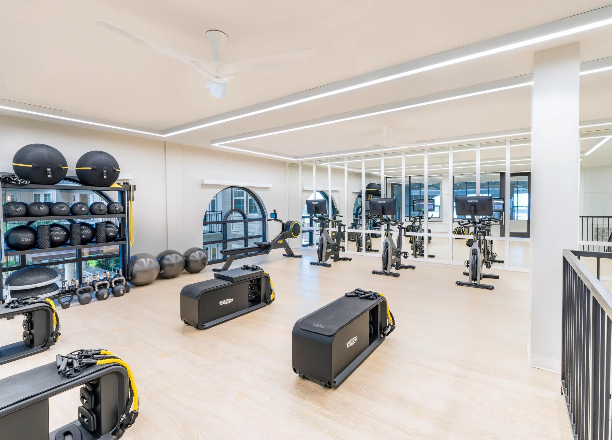 Fitness studio with multiple workout stations and cardio equipment