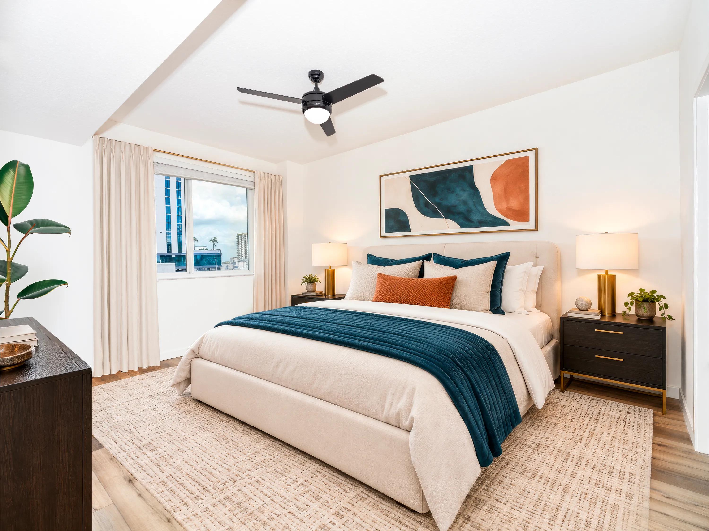 Primary bedroom with oversized windows, wood-style flooring, a ceiling fan, contemporary finishes, and city views at Modera Encore apartments in Tampa, FL.