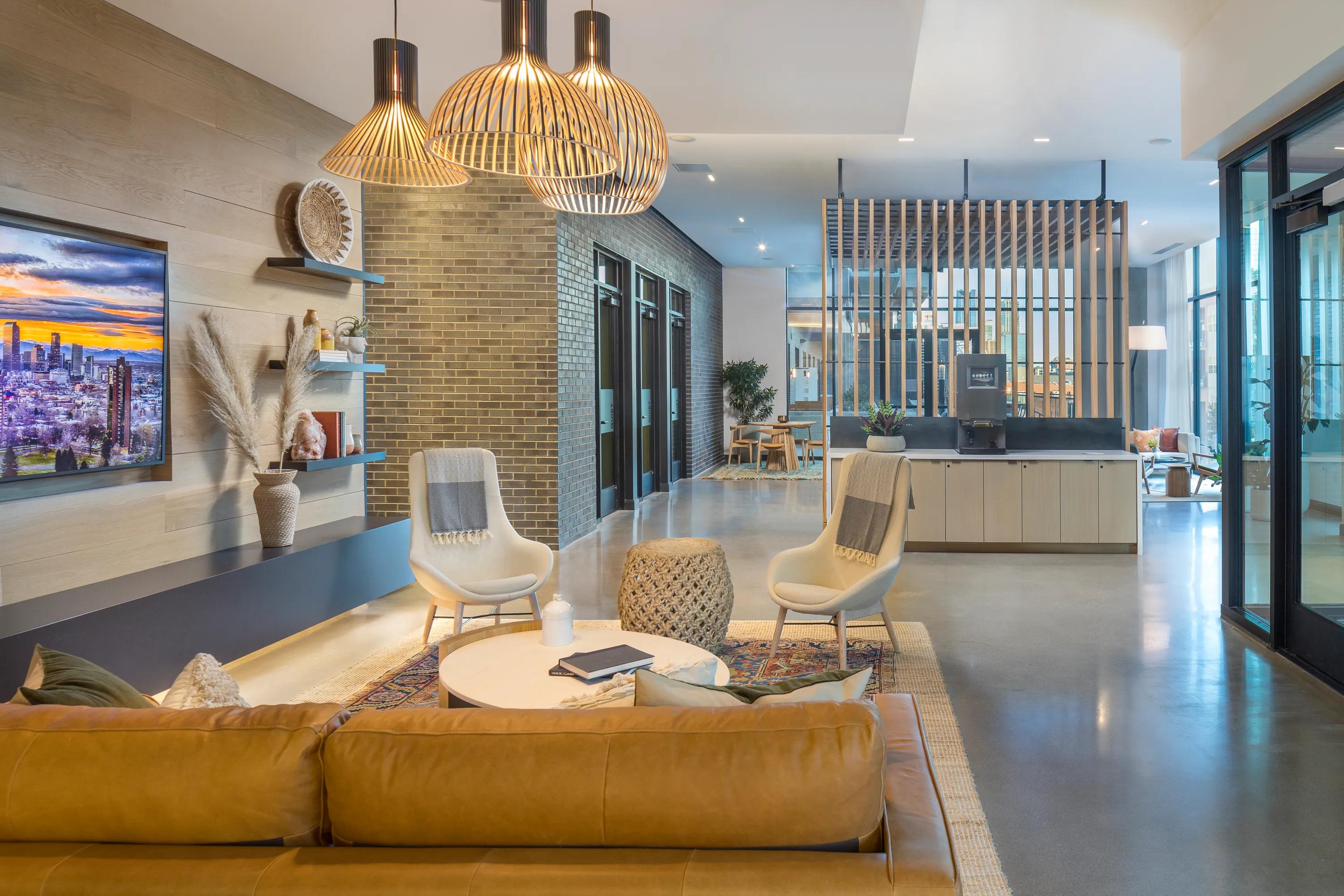 Indoor/outdoor bar and lounge area with kitchen and flat screen TVs modera lohi apartments in denver co