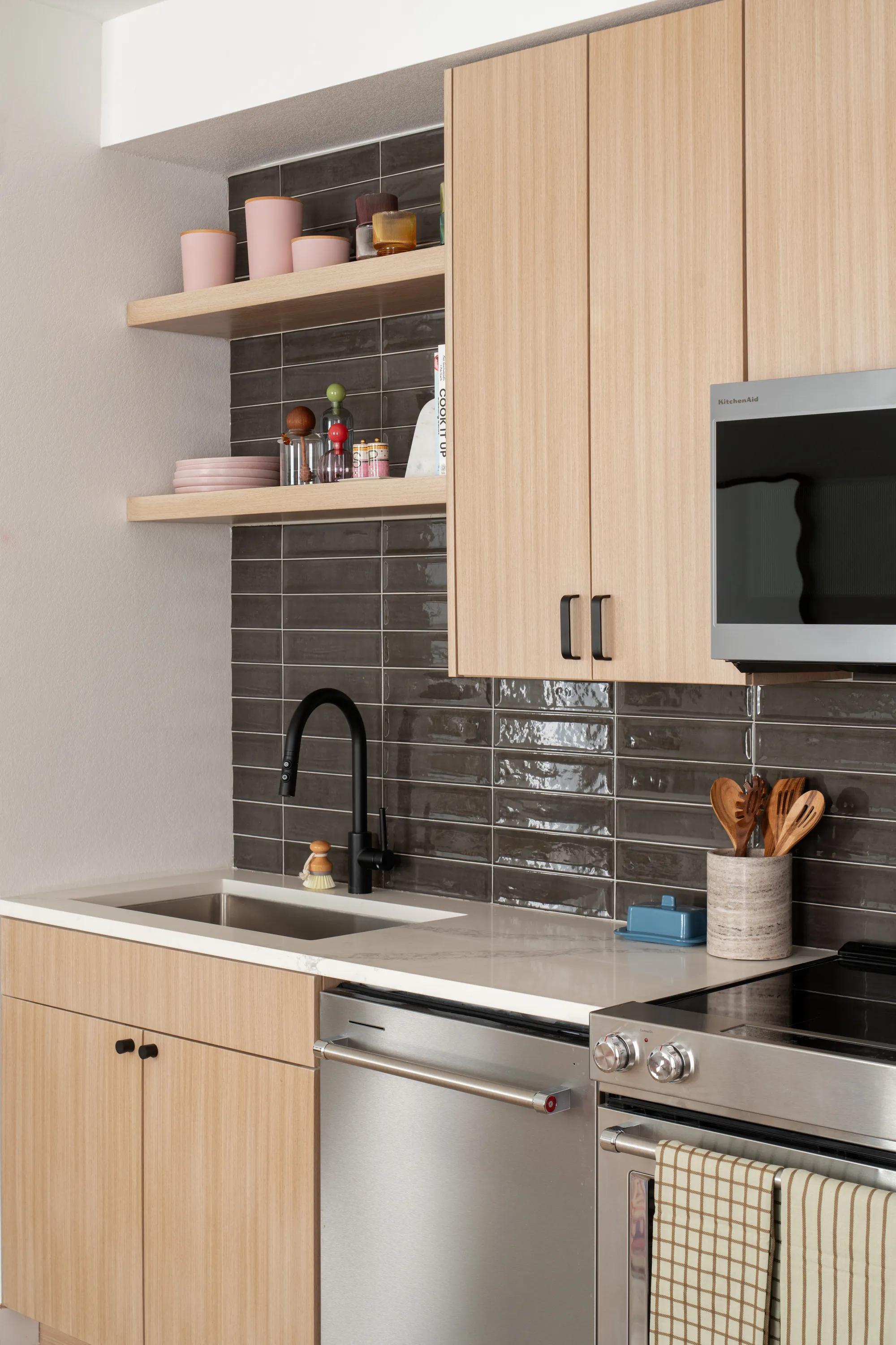 focus on light wood kitchen with stainless steel appliances and black tile backsplash modera rio salado apartment homes for rent in tempe az