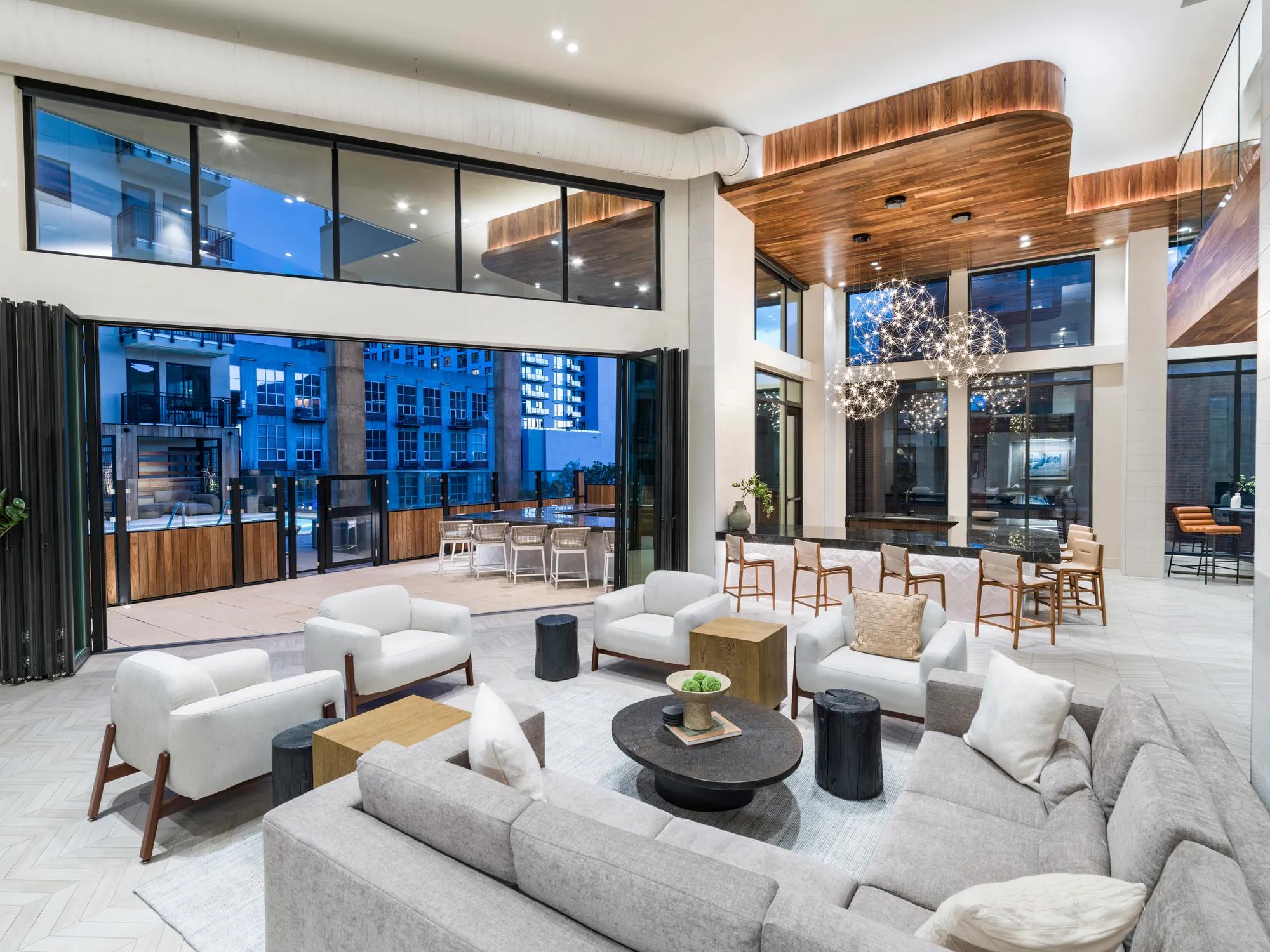 clubhouse seating with indoor outdoor space in the evening modera golden triangle apartment homes for rent in denver co
