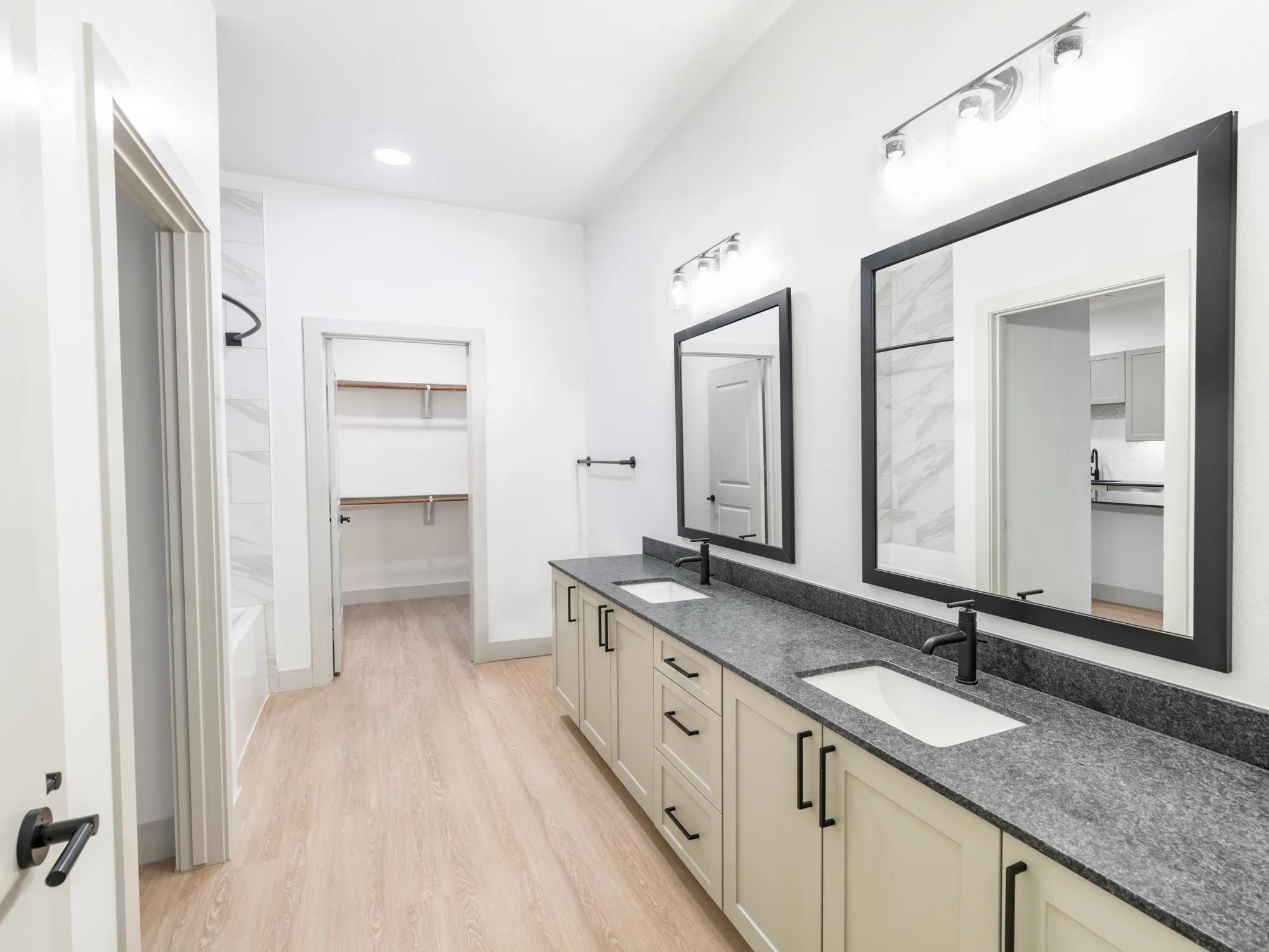 long double vanity bathroom with dark countertops and large closet modera mckinney ridge apartment homes for rent in tx
