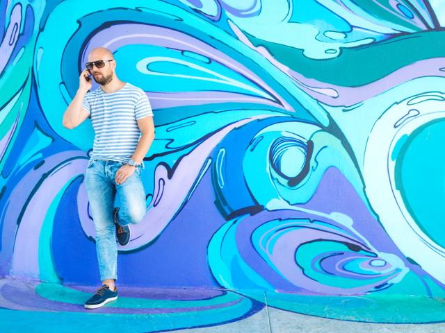 man standing in front of blue art mural modera riverside apartment homes for rent in miami fl
