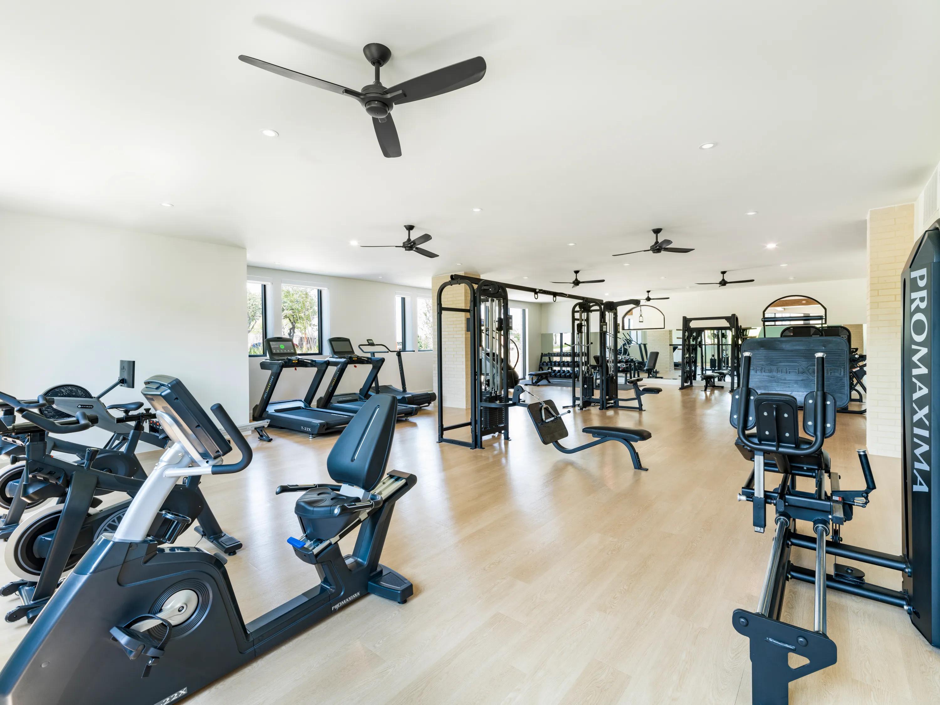 Fitness studio with multiple workout stations and cardio equipment modera trailhead apartments dallas tx