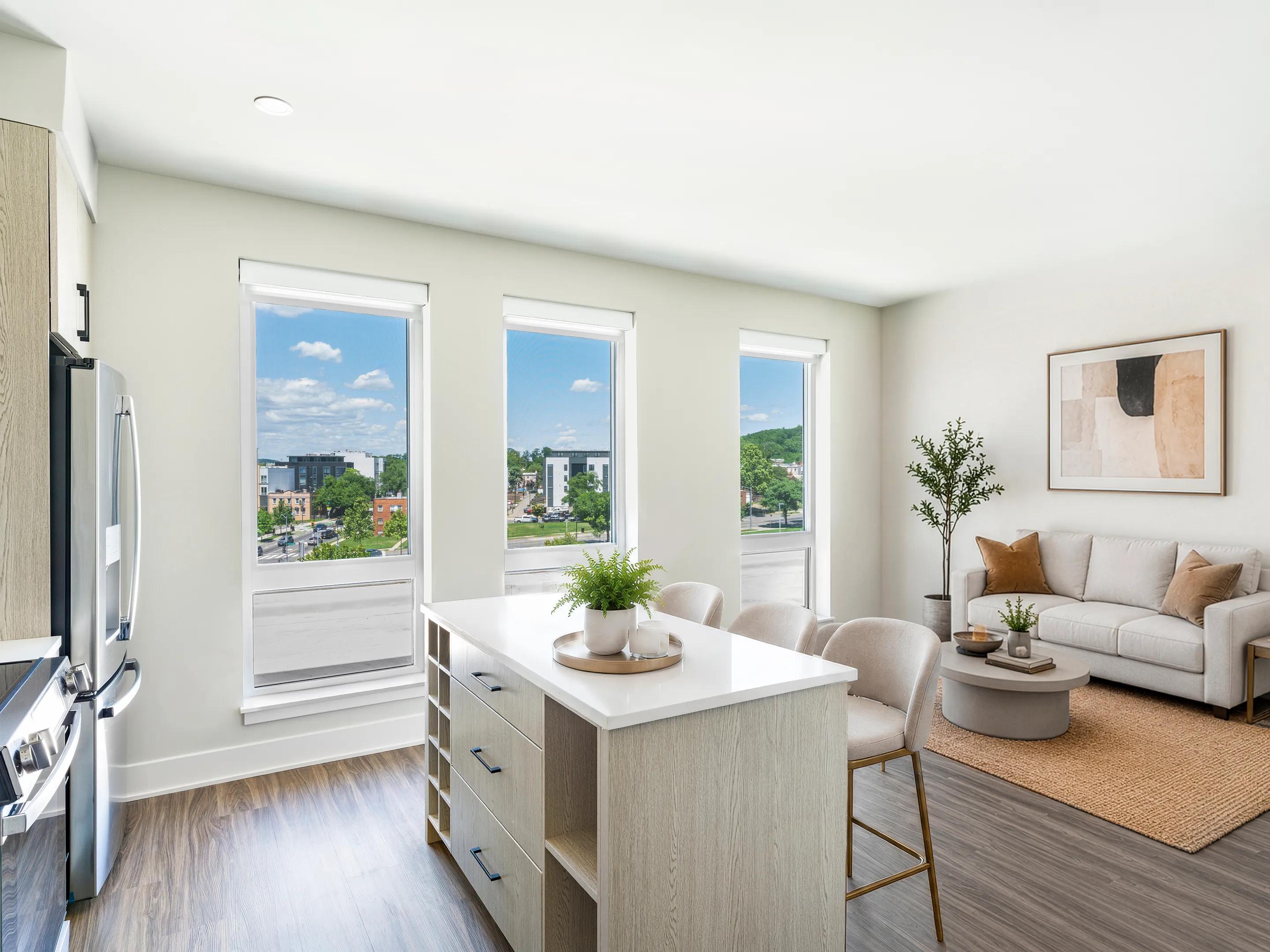 open kitchen and living area with a central island and tall windows modera h street apartments washington dc