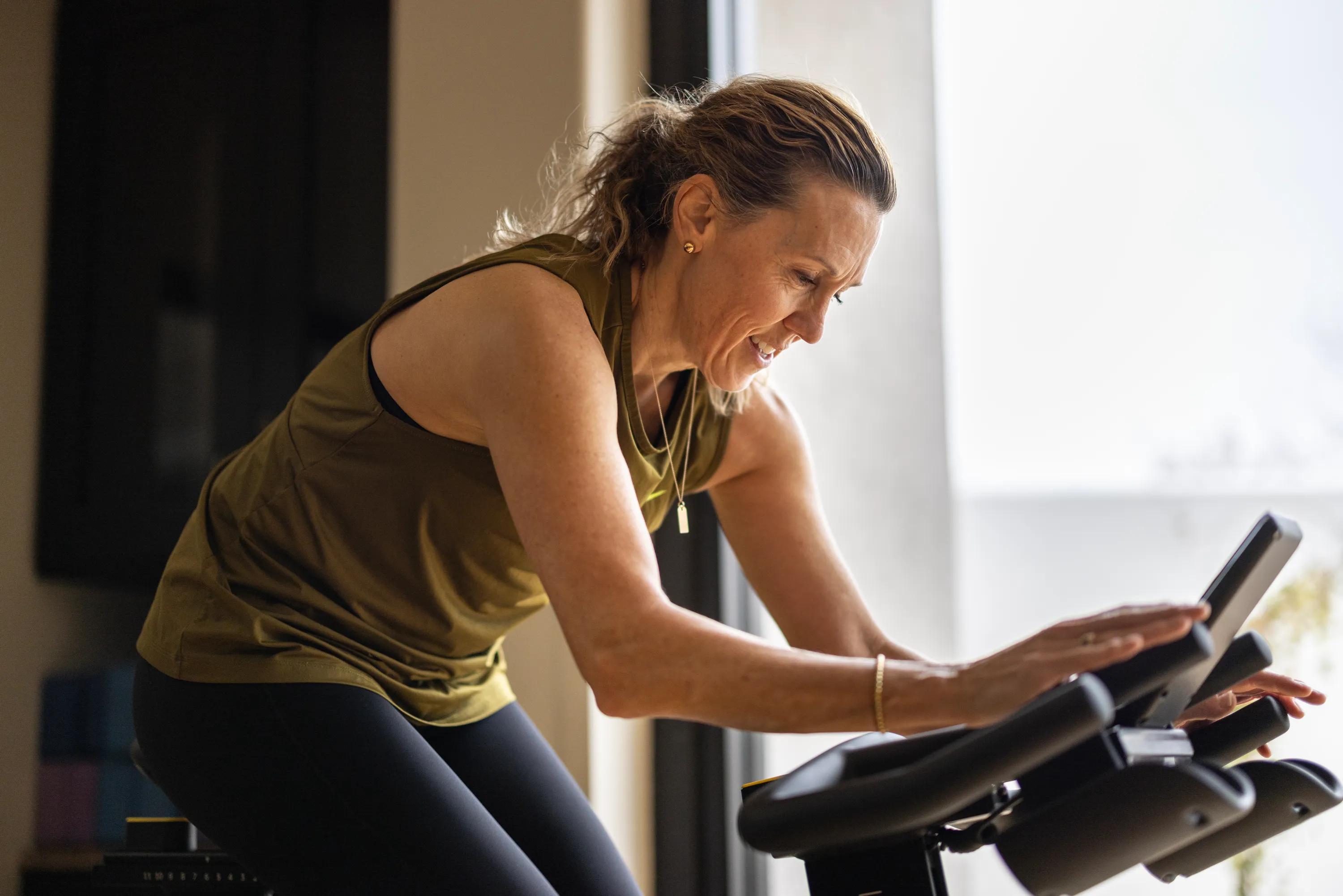 woman on spin bike fitness center modera weston ma apartments near boston