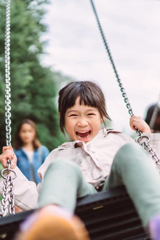 young girl on swing set smiling modera walsh heights apartments in aledo tx