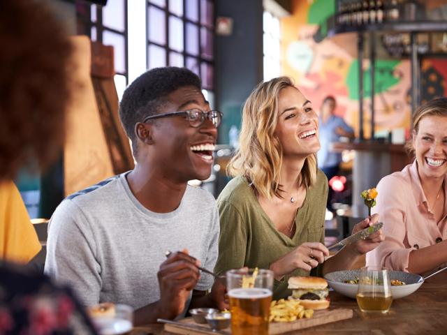 group of friends eat and smiling at a restaurant modera rio salado neighborhood apartments in tempe az