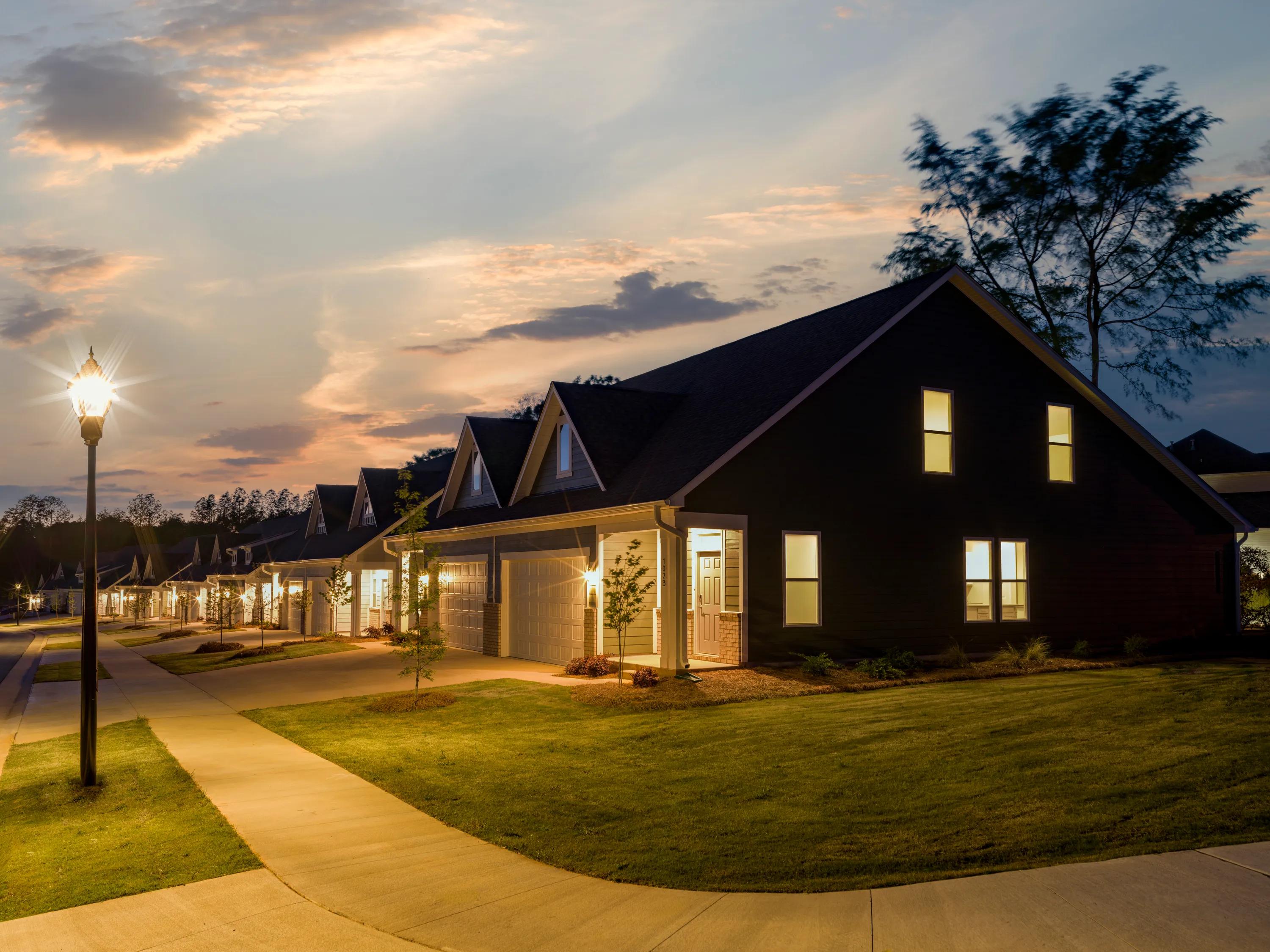 night street corner view of row of homes with lights on and sidewalks amavi mooresville apartment homes for rent in nc