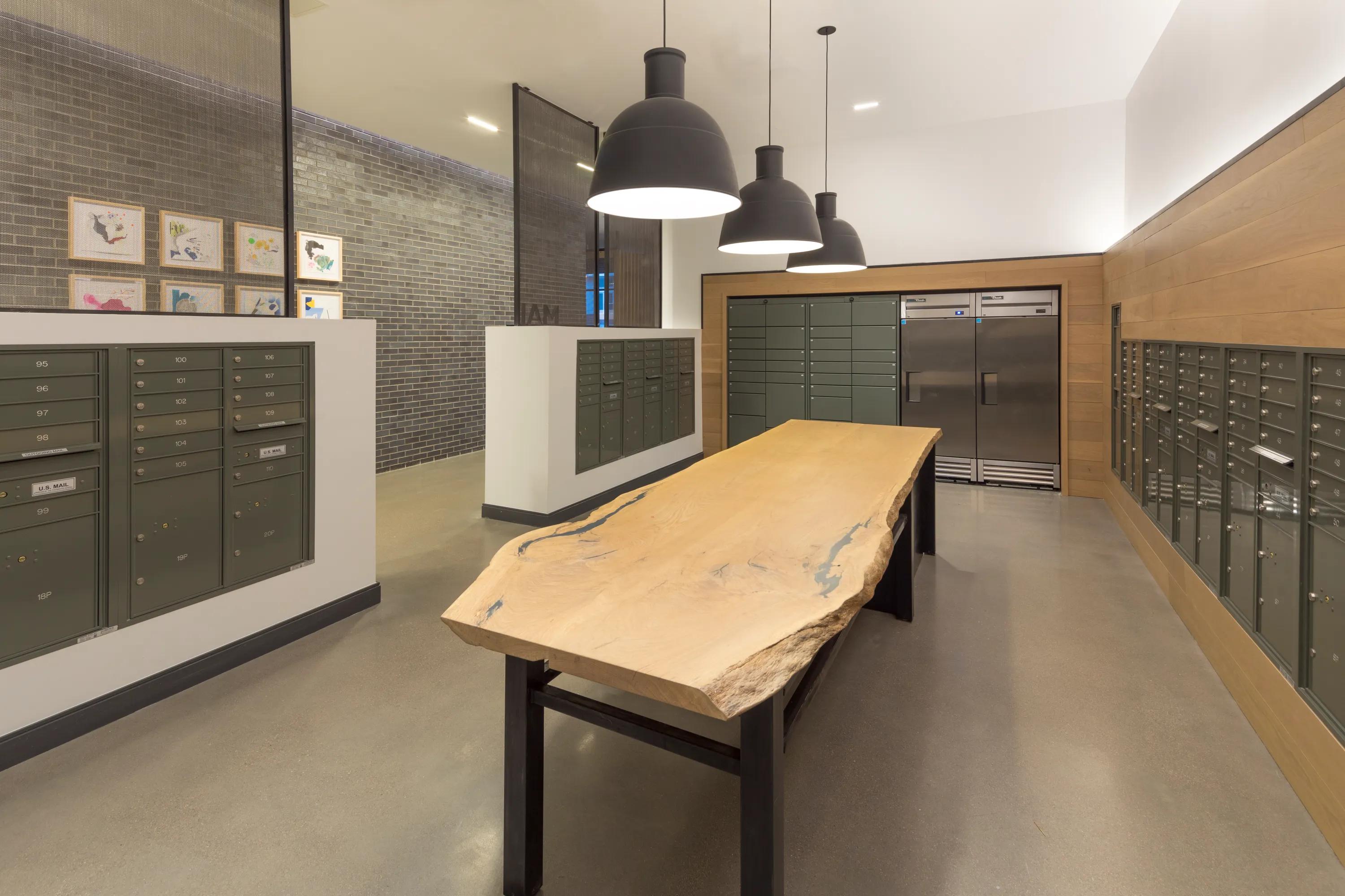 24-hour package concierge and mailroom featuring large natural-edged wooden table and package lockers