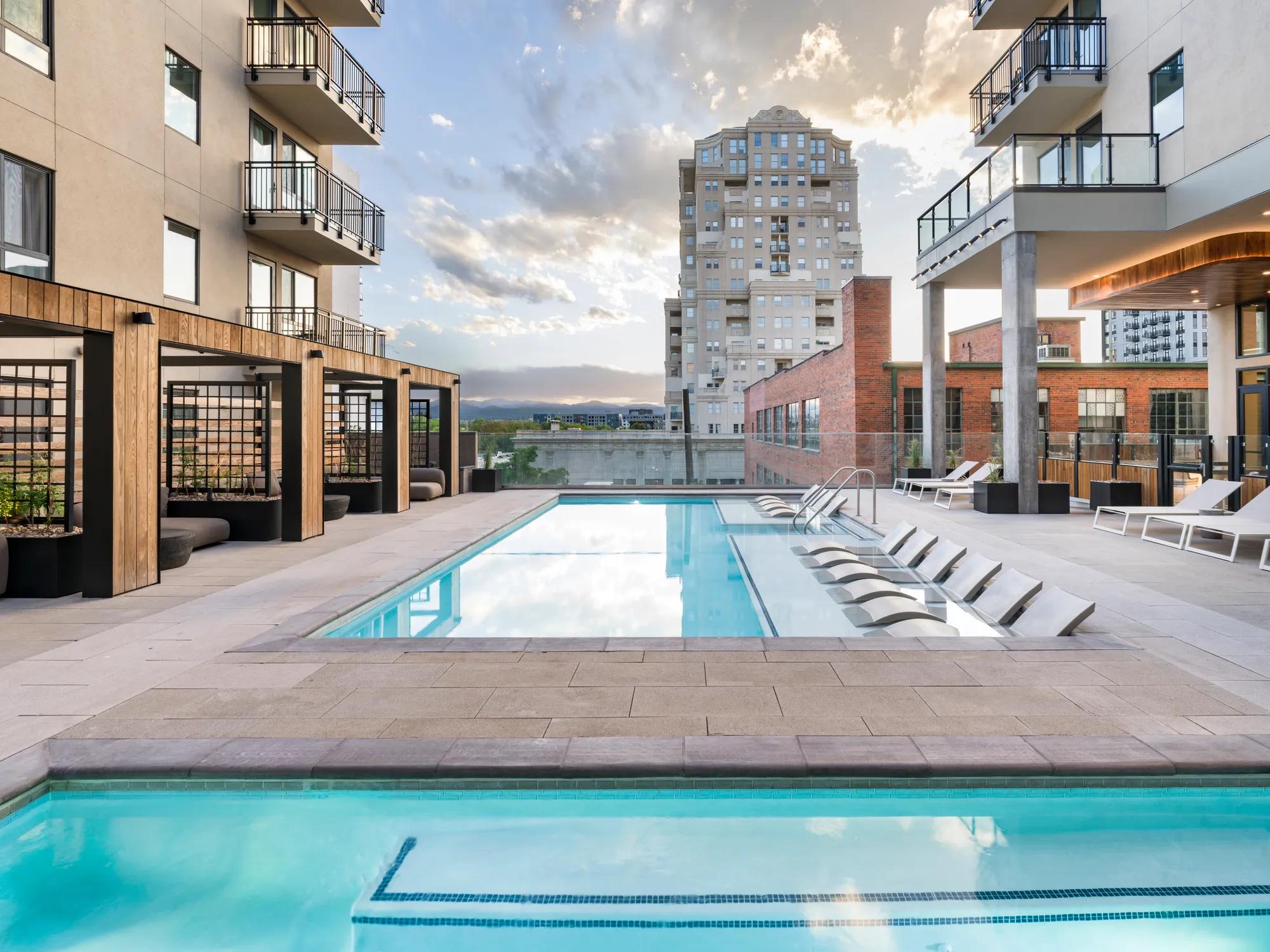 two pools with lounge seating and cabanas adjacent on sundeck modera golden triangle apartment homes for rent in denver co