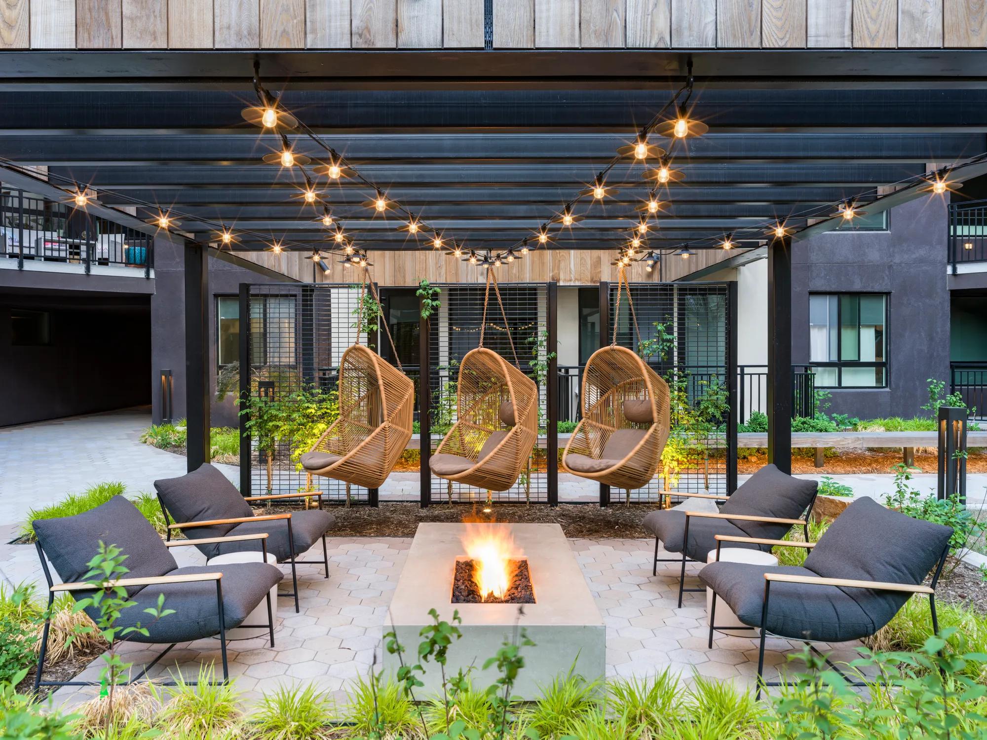 stylish seating and firepit in courtyard with greenery and string lights modera golden triangle apartment homes for rent in denver co