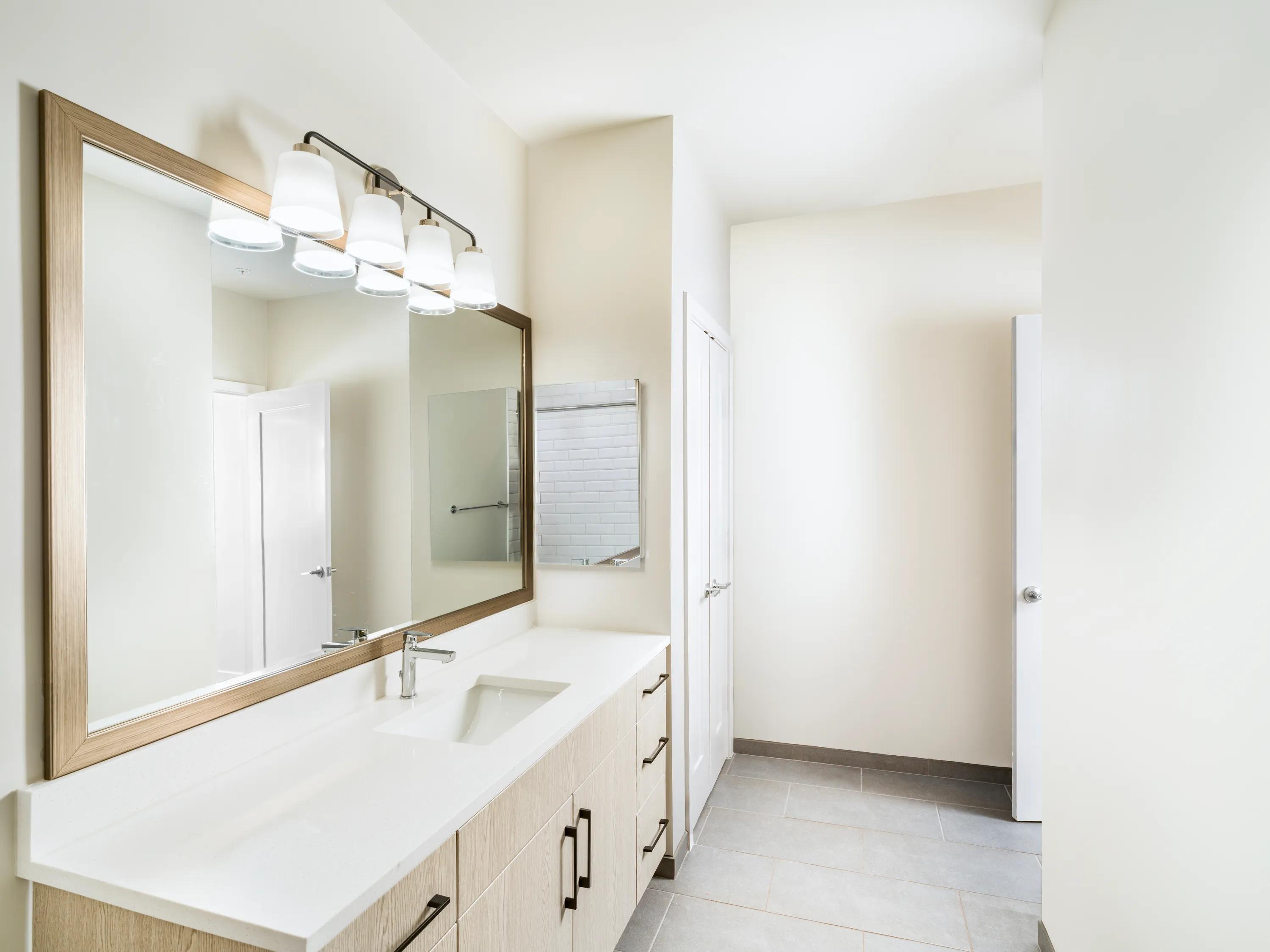 primary bathroom with a long quartz vanity modera h street apartments washington dc