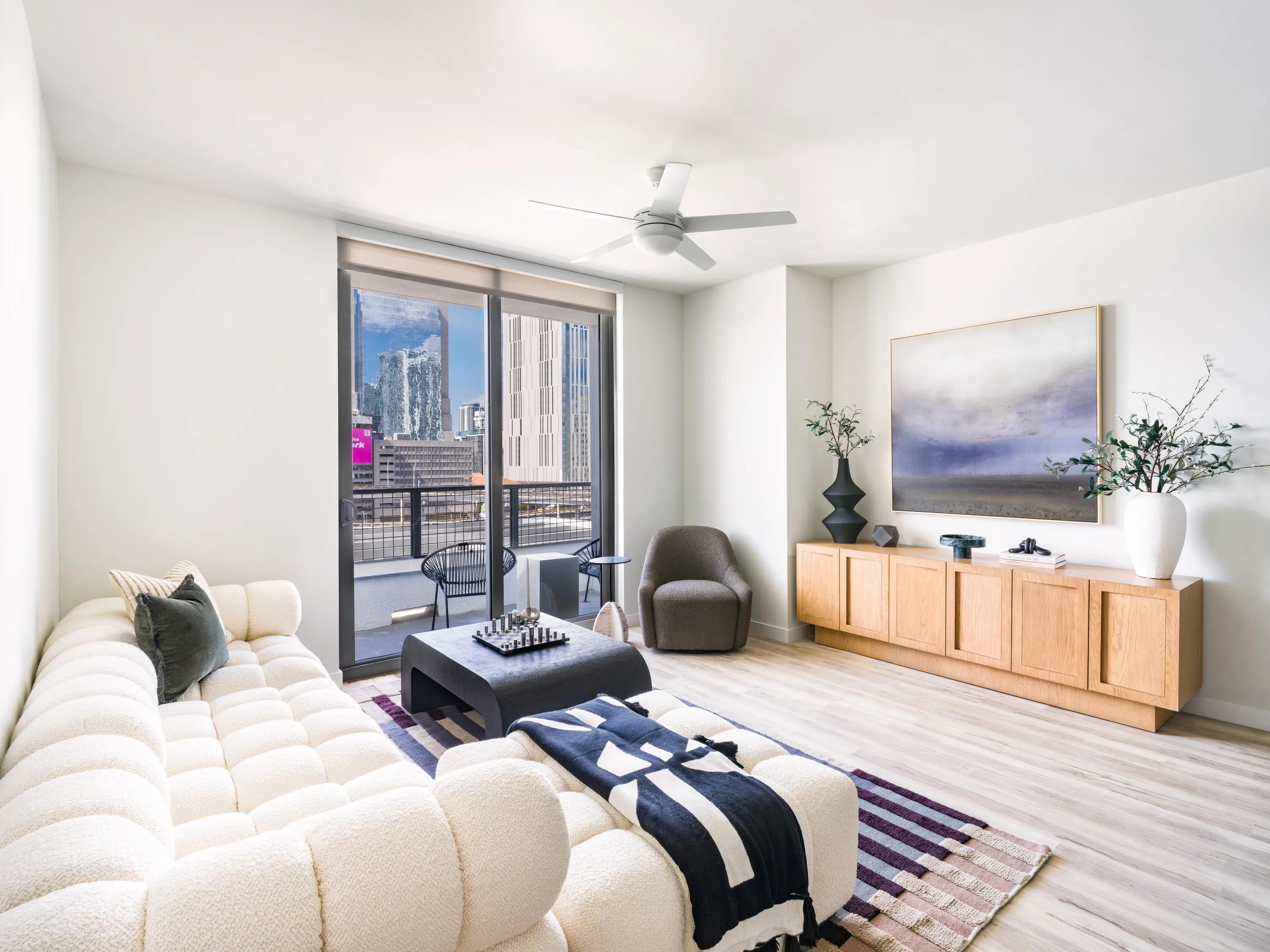 living room facing balcony with large windows bedroom with large windows looking towards city modera riverside apartment homes for rent in miami fl