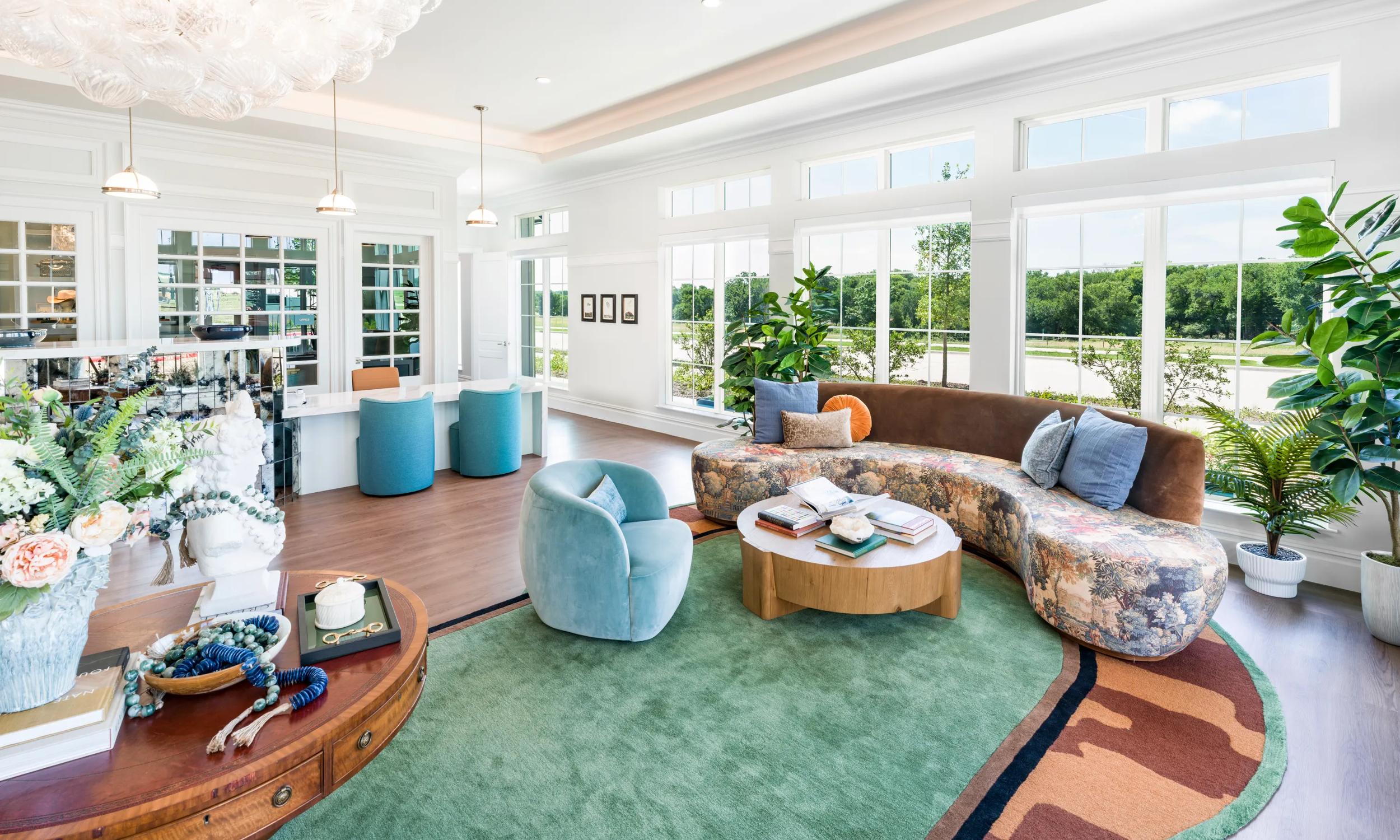 Luxurious living room with elegant chandelier, cozy fireplace, and stylish seating area, leading to a modern open kitchen.