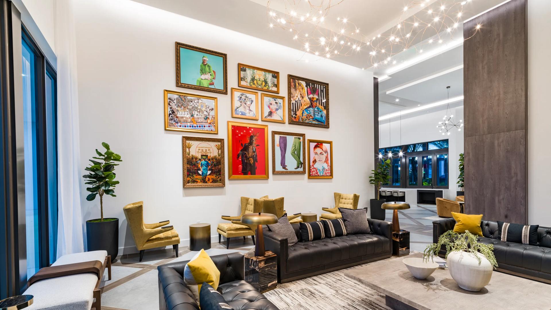 Luxurious modern lounge with high ceilings, elegant art pieces, and sophisticated seating amidst natural light and greenery.