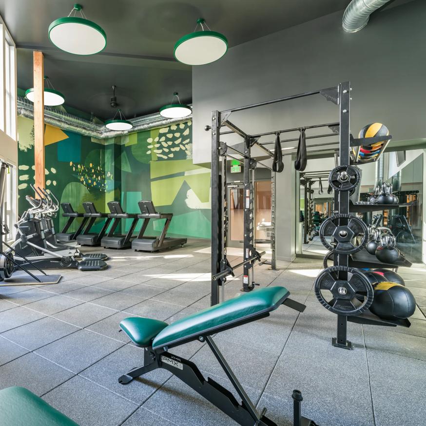 man on exercise bike in gym working out modera northgate apartment homes for rent