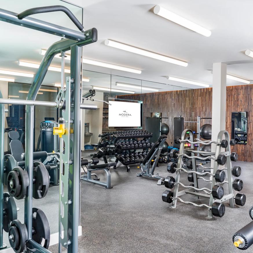 woman on exercise bike in gym at modera pomona apartment homes for rent in ca