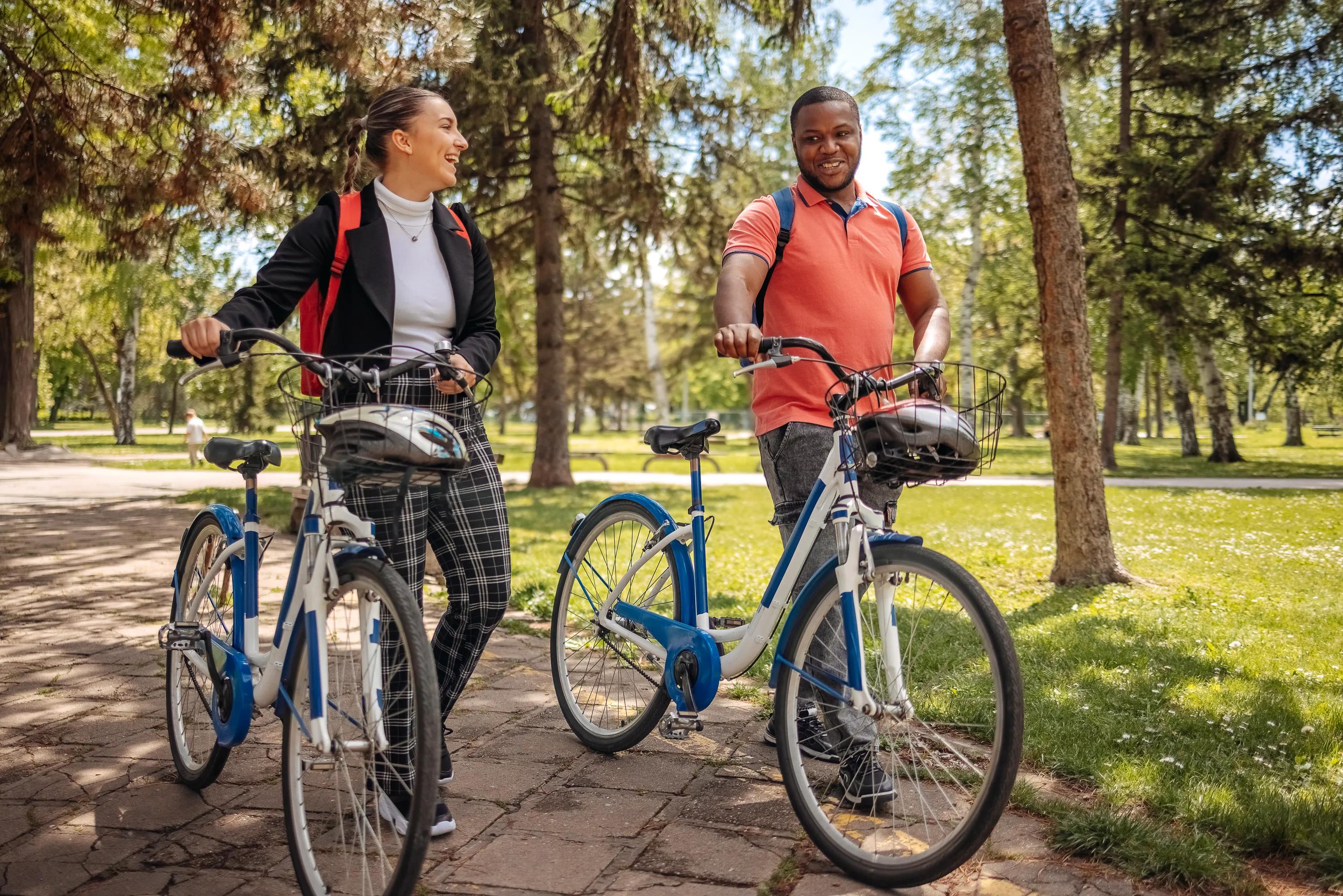 two people walking bike on trail near grass field modera trailhead apartment homes for rent in dallas tx