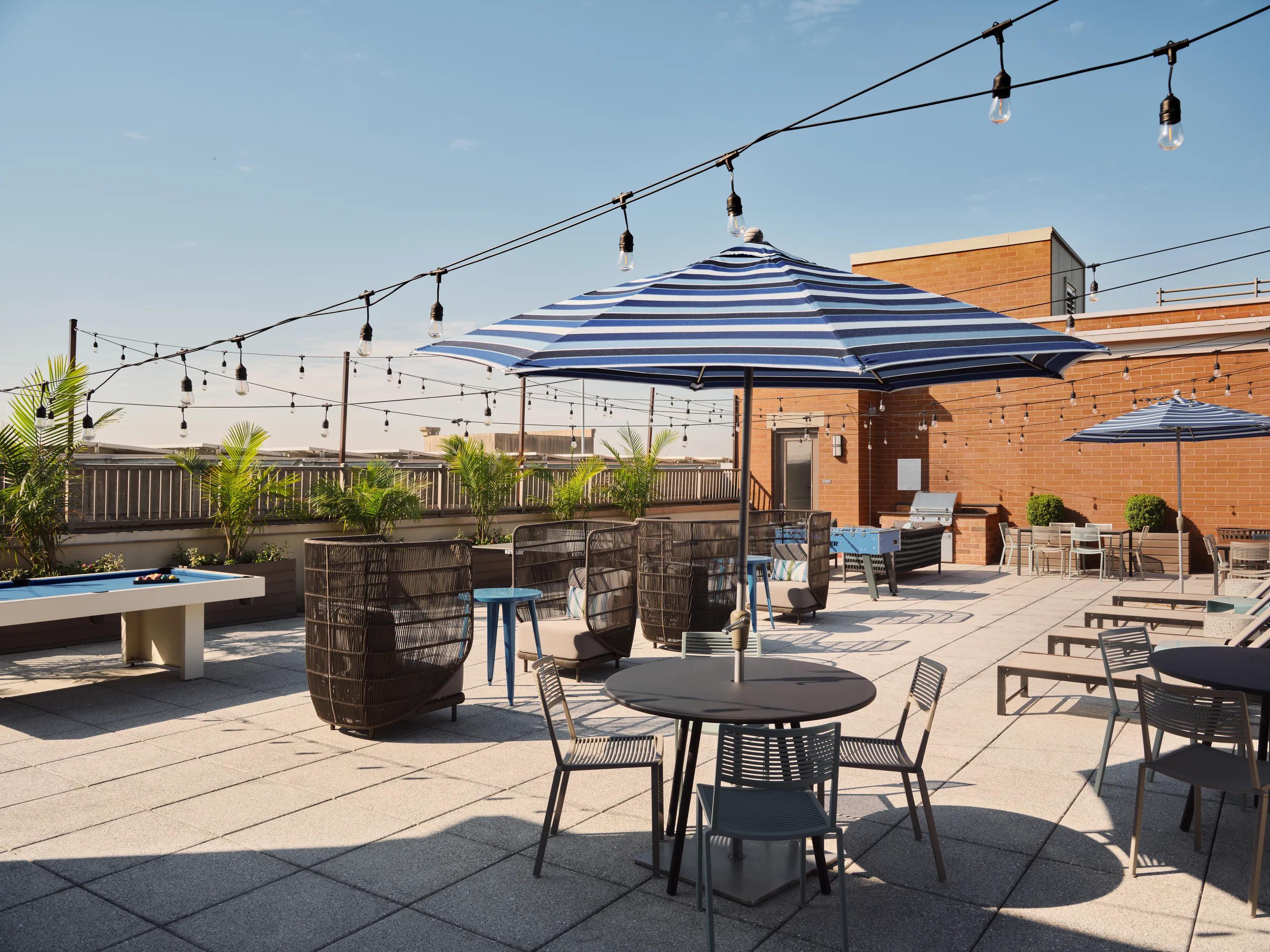 outdoor dining and gaming options with string lighting overhead metropolitan at 40 park apartment homes for rent in morristown nj
