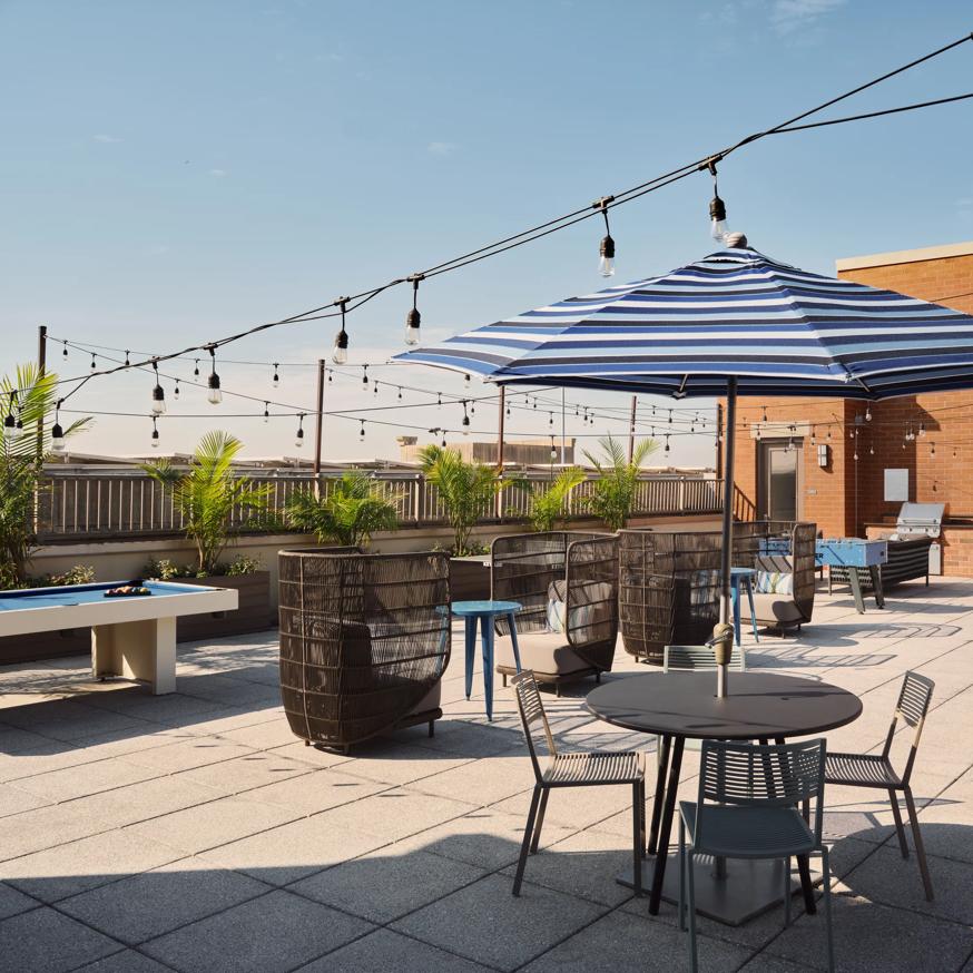 rooftop lounge with pool table and umbrella metropolitan at 40 park apartment homes for rent in morristown nj
