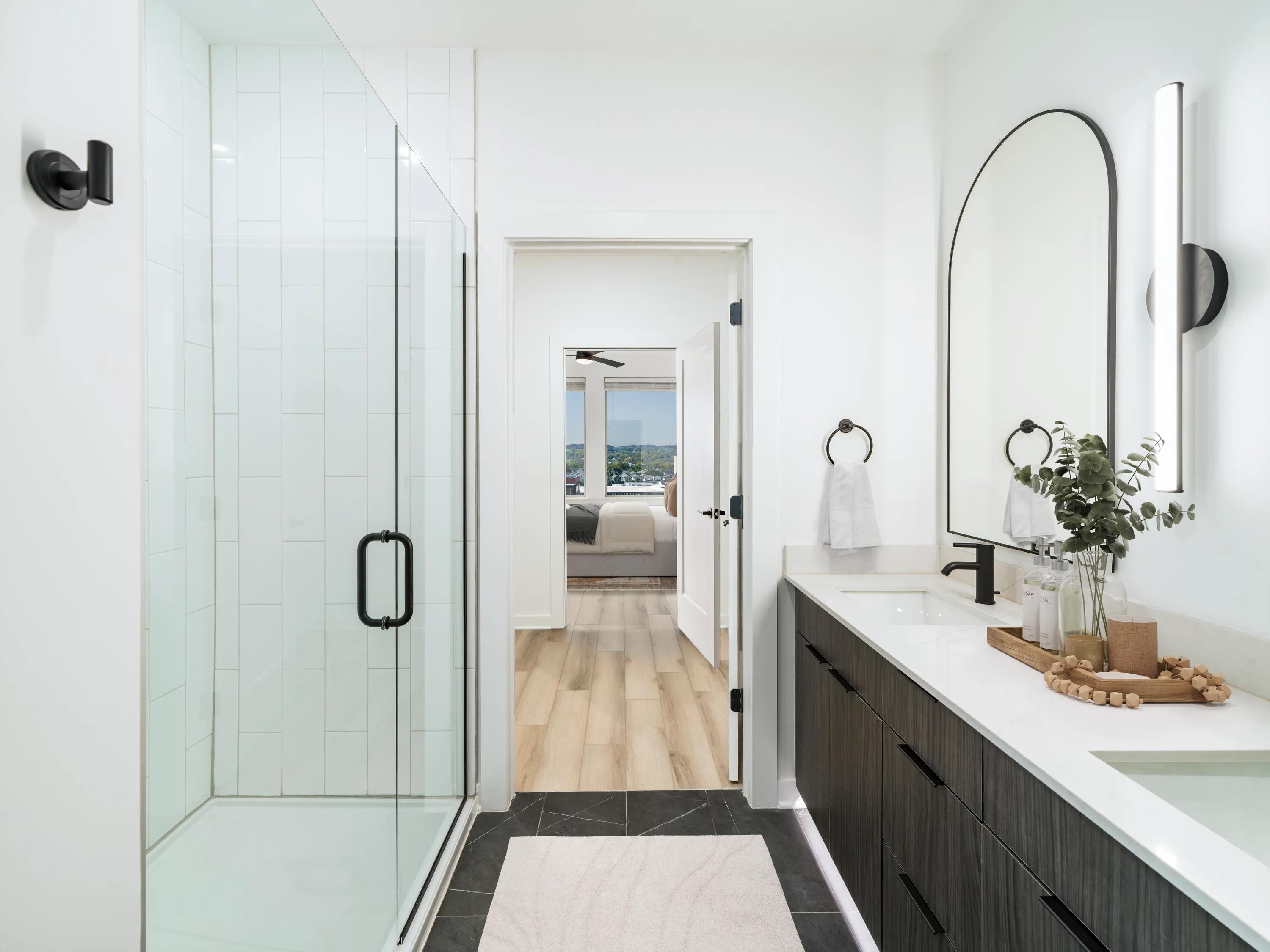 bathroom with dark cabinetry and walk in shower modera nations nashville tn apartments for rent