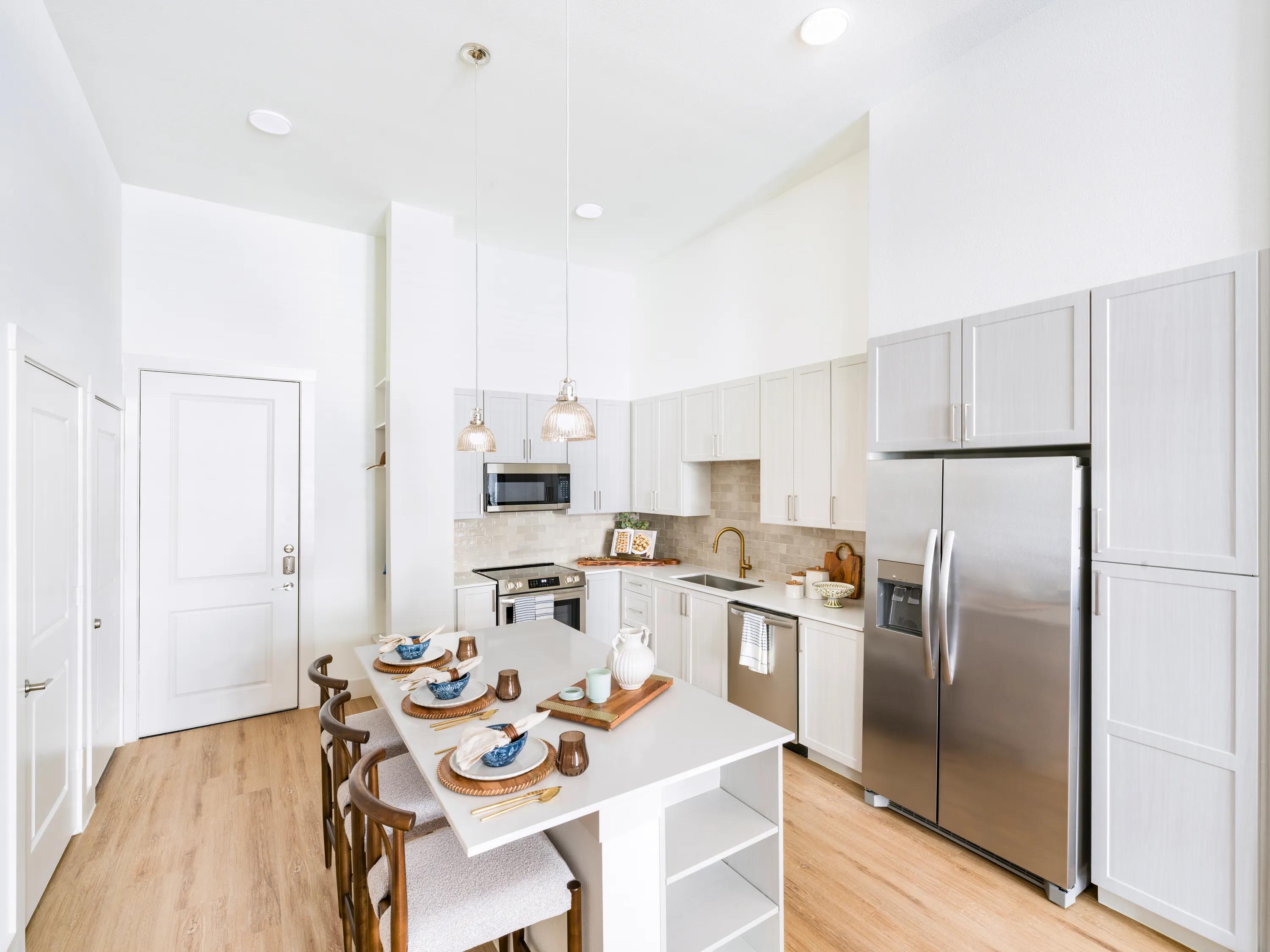kitchen view with large island for storage and seating modera walsh heights apartments aledo tx