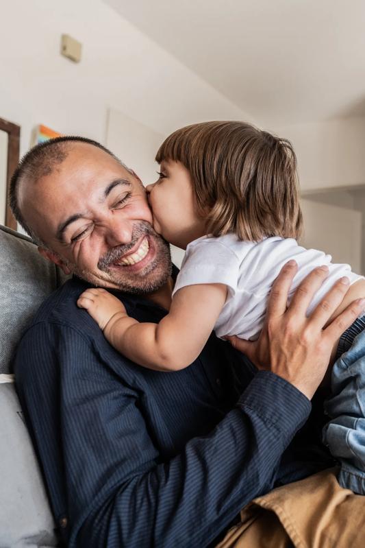 father and baby playing while baby kisses dad on cheek and father is smiling modera apartments