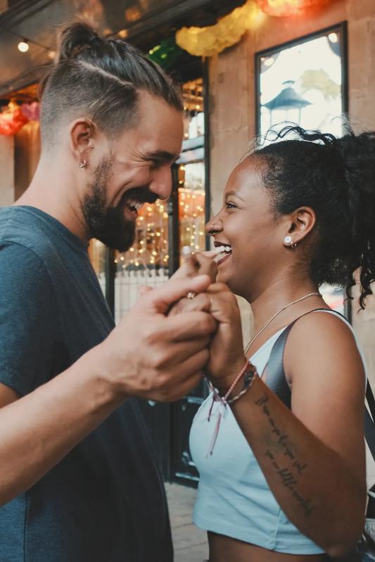 young couple holding hands and looking at each other smiling in a shopping area denver co
