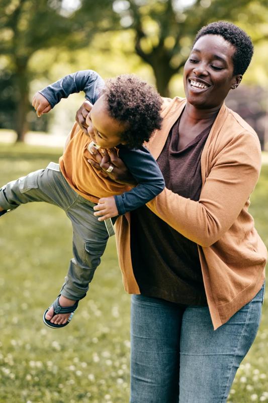 Woman swinging child outside near Modera Natick Center Apartments for rent