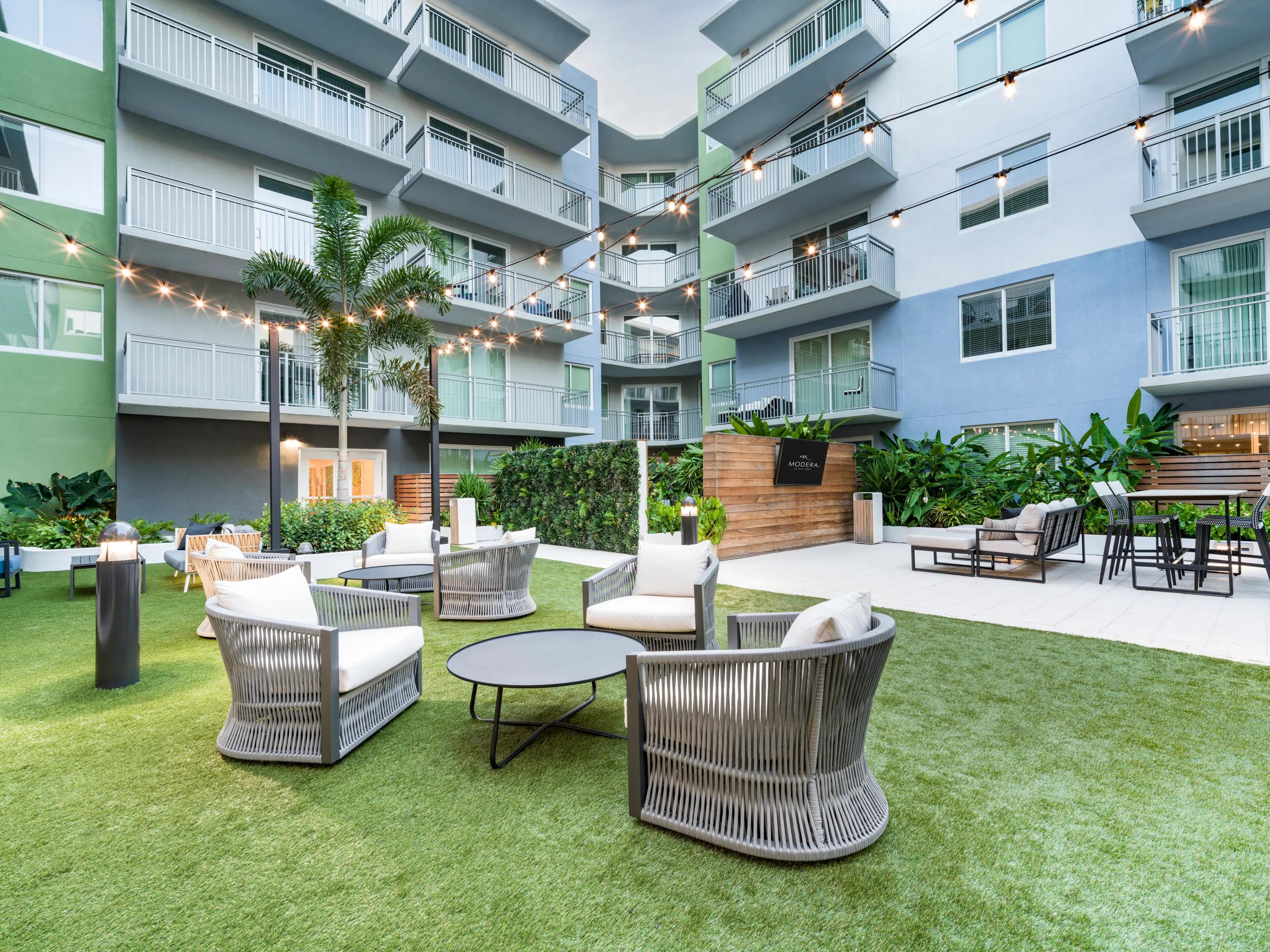 Outdoor courtyard with grilling area, activity lawn, and lounge seating