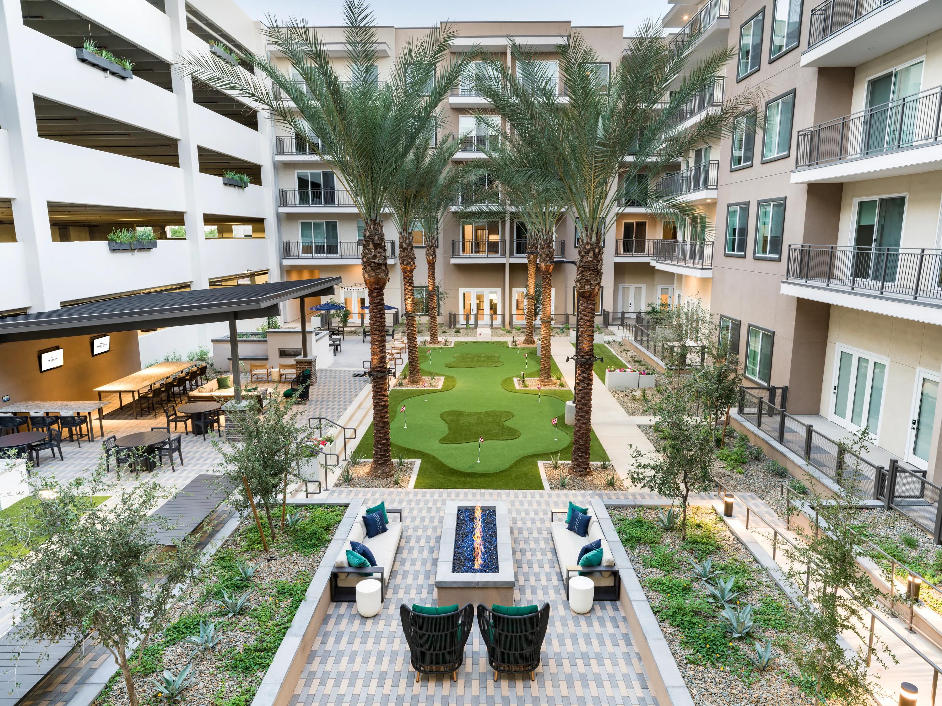 courtyard with grass area and umbrella seating modera kierland apartment homes for rent in scottsdale az