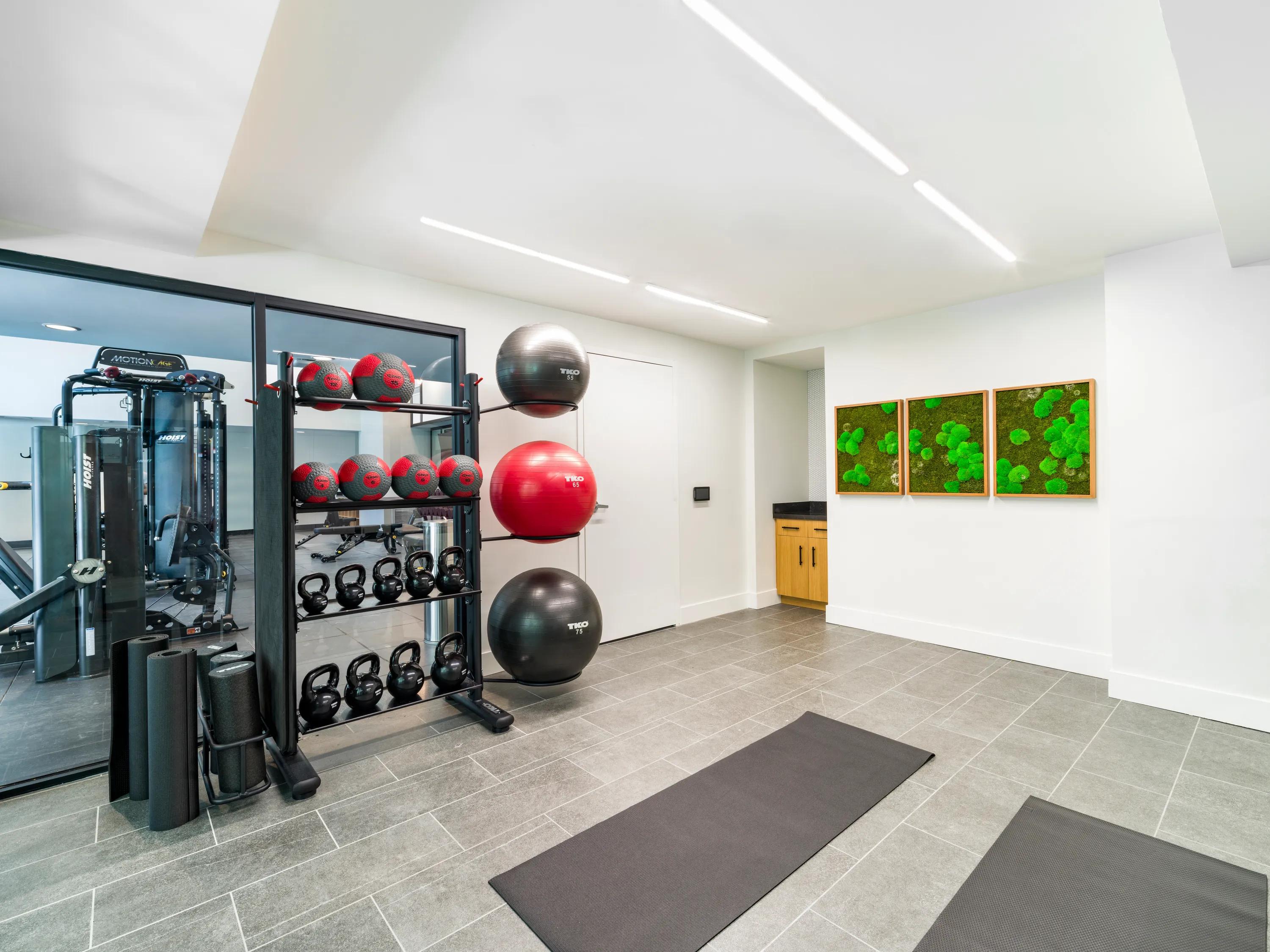 Fitness studio training area with kettlebells, medicine balls, yoga mats, strength equipment, and dedicated space for stretching and functional fitness at Modera Encore apartments in Tampa, FL.